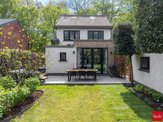 <p><strong>Stijlvolle open bebouwing in een rustige, groene omgeving nabij het centrum</strong><br /><br />In een rustige, boomrijke straat in een groene en gegeerde woonomgeving ontdekt u deze stijlvolle open bebouwing, waar rust, comfort en kwaliteit samenkomen. Scholen, winkels en openbaar vervoer bevinden zich op korte afstand, waardoor de ligging een ideale balans biedt tussen privacy en bereikbaarheid.</p>
<p>Zodra de automatische poort opent, wordt u meteen gecharmeerd door de woning en haar elegante, verzorgde uitstraling<strong>.</strong> De architecturale eenvoud, de harmonieuze inplanting en de verzorgde voortuin zetten onmiddellijk de toon voor wat volgt.</p>
<p>Binnen wordt u verwelkomd in een woning waar sfeer en verfijning centraal staan. Warme houten parketvloeren, subtiele gietijzeren accenten en zorgvuldig maatwerk creëren een tijdloze en elegante woonbeleving.</p>
<p>De leefruimte vormt het kloppend hart van de woning. Dankzij de grote raampartijen baadt de ruimte in natuurlijk licht en geniet u van een mooi zicht op de tuin. De open keuken sluit naadloos aan en versterkt het gevoel van ruimte, licht en verbondenheid.</p>
<p>De woning werd praktisch en doordacht ingedeeld met een inkomhal met gastentoilet en vestiaire, een ruime bijkeuken/wasplaats, een kelder en een ingemaakte bureauruimte die discreet in het geheel werd geïntegreerd.</p>
<p>Op de verdiepingen bevinden zich drie volwaardige slaapkamers, elk met hun eigen karakter. De master bedroom is uitgerust met airconditioning en beschikt over een royale badkamer met ligbad/douche en dubbele lavabo. De tweede slaapkamer geniet van een eigen douchekamer. De derde slaapkamer, gelegen op de bovenste verdieping en bereikbaar via een vaste trap, is volledig afgewerkt en voorzien van ingemaakte kasten die het geheel versterken.</p>
<p>Buiten wordt u omringd door groen en privacy. De aangelegde tuin met volwassen bomen vormt een serene buitenruimte waar u in alle rust kan ontspannen. Het perceel is volledig omheind en voorzien van een automatische poort en alarmsysteem, wat bijdraagt aan een veilig en comfortabel woongevoel.</p>
<p>Tot slot beschikt de woning over een losstaande garage met raampartijen, vandaag ingericht als fitnessruimte, waardoor ook hier flexibiliteit en multifunctionaliteit centraal staan.</p>
<p><strong>Troeven:</strong></p>
<ul>
<li>Instapklaar en hoogwaardig afgewerkt</li>
<li>Rustige, groene en gegeerde ligging</li>
<li>Lichtrijke leefruimte met open keuken</li>
<li>Twee badkamers</li>
<li>Aangelegde tuin met maximale privacy</li>
<li>Volledig omheind perceel met automatische poort</li>
<li>Alarmsysteem aanwezig</li>
<li>Kelder en praktische bergruimtes</li>
<li>Multifunctionele garage (momenteel fitnessruimte)</li>
</ul>
<p><br />Voor meer informatie of een bezichtiging aan deze gezellige woning, neem contact met Sigalit via sigalit@reds.be of op 0475668474</p>