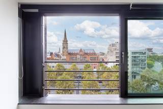 <p>Ce bel appartement d’environ 70 m² (selon le PEB) est situé au sixième étage d’un immeuble à taille humaine sur l’Italiëlei. Idéalement situé au cœur de la ville, à proximité de la Paardenmarkt, de l’Operaplein, du Meir et de la Gare Centrale. Les Leien assurent une excellente accessibilité.<span></span></p>
<p>La pièce de vie bénéficie d’une belle luminosité naturelle grâce à sa grande baie vitrée coulissante. Presque entièrement ouverte, celle-ci prolonge agréablement l’espace de vie et crée une véritable sensation de terrasse couverte, avec une vue dégagée sur la ville en toile de fond.</p>
<p>La cuisine ouverte s’intègre harmonieusement à l’espace de vie et est entièrement équipée d’un réfrigérateur avec compartiment congélateur, d’une plaque de cuisson vitrocéramique, d’un lave-vaisselle et d’un four à micro-ondes combiné.</p>
<p>La chambre se situe au calme, à l’arrière de l’immeuble, et jouxte la salle de bains équipée d’une douche à l’italienne et d’un lavabo.</p>
<p>L’appartement dispose également d’un espace de rangement pratique avec raccordements pour machine à laver et sèche-linge, ainsi que de toilettes séparées.</p>
<p>Une cave privative est incluse dans le prix.</p>