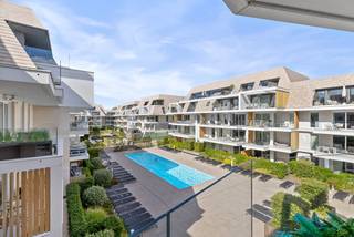 Deze uitzonderlijke herverkoop bevindt zich in de nieuwbouw residentie Sailors’ Park, een uniek project gelegen tussen Nieuwpoort-Bad en Nieuwpoort-Stad. De residentie werd ontworpen met één duidelijke gedachte: ruimte creëren om te ontspannen en volop te genieten.<br /><br />Binnen het project beschikt u over een uitgebreid aanbod aan gemeenschappelijke faciliteiten. Het verwarmde openluchtzwembad en het aparte plonsbad vormen de ideale plek om tijdens zonnige dagen te ontspannen of rustig enkele baantjes te trekken. Rondom het zwembad bevindt zich een fraai aangelegde recreatiezone met rustbanken, waar u in alle sereniteit kunt genieten van de groene omgeving. Daarnaast zorgen de petanque- en zandbak voor een aangename invulling en een gezellige ontmoetingsplek.<br /><br />Ook op praktisch vlak is aan het nodige comfort gedacht. De gemeenschappelijke delen worden deels van energie voorzien door zonnepanelen, er zijn afvalcontainers met ophaling en de residentie beschikt over een gemeenschappelijk wassalon.<br /><br />Het appartement bevindt zich op de tweede verdieping van deelresidentie Zephir en geniet dankzij zijn ligging van een aangename indeling. De inkomhal met afzonderlijk gastentoilet geeft toegang tot de leefruimte met open keuken. Verder vinden we er de badkamer met inloopdouche, twee slaapkamers uitgevend op het ruime terras van maar liefst 26,02 m², een bijzonder aangenaam verlengde van uw leefruimte met fantastisch zicht over het recreatiedomein en zwembad.<br /><br />De combinatie van de comfortabele indeling, het royale terras en de uitgebreide faciliteiten van Sailors’ Park maakt dit appartement geschikt als vaste verblijfplaats, tweede verblijf of interessante investering aan de Belgische kust.<br /><br />Een garage en ruime berging is bijkomend beschikbaar voor €65.000.<br /><br />Verkoop onder registratierechten.