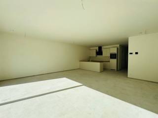 Dit moderne en lichtrijke gelijkvloersappartement is rustig gelegen en biedt een aangename woonomgeving met een privatieve tuin en terras. Daarnaast beschikt het appartement over een gemeenschappelijke fietsenberging en een achterliggende autostaanplaats.Bij het betreden van het appartement komt u terecht in de inkomhal met een apart gastentoilet. Van daaruit heeft u toegang tot de open keuken, die volledig is ingericht en voorzien van alle nodige toestellen. De keuken sluit naadloos aan op de ruime leefruimte met eetplaats, waar de grote lichtinval zorgt voor een aangenaam en open gevoel. Via de leefruimte bereikt u rechtstreeks het terras en de tuin, ideaal om in alle rust van het buitenleven te genieten. Verder zijn er in de gang twee praktische bergruimtes aanwezig, waarvan één uitgerust is met aansluitingen voor een wasmachine. Het appartement beschikt over één ruime slaapkamer, een aparte bureauruimte en een moderne badkamer. Deze laatste is voorzien van een inloopdouche, een dubbele lavabo met badkamermeubel, een handdoekdroger en een spiegelkast met verlichting.Ook op vlak van comfort en afwerking heeft deze woning heel wat te bieden: verwarming via een warmtepomp, zonnepanelen, een hoogwaardige afwerking, een gemeenschappelijke fietsenberging en een extra toegang achteraan. Bovendien is het appartement splinternieuw en volledig geschilderd, waardoor u meteen kunt genieten van een frisse en verzorgde woonomgeving. Een achterliggende autostaanplaats is verplicht bij te huren voor € 50 per maand. Het appartement is beschikbaar vanaf 1 november 2026.Ziet u zichzelf hier al thuiskomen en genieten van het comfort, de rust en de gezellige tuin? Neem dan gerust vrijblijvend contact met ons op voor meer informatie of een bezoek ter plaatse!
