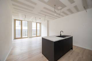 <p><span>Exclusief wonen in 'The Vault': Modern 1-slaapkamerappartement in hartje Antwerpen</span></p><p><span>Droomt u van een luxueuze uitvalsbasis in de bruisende Antwerpse Theaterbuurt? Welkom in 'The Vault', een architecturaal hoogstandje van de hand van Luc Binst. Dit exclusieve nieuwbouwproject combineert de energie van het stadscentrum met de serene rust van een verkeersluwe zijstraat. Hier woont u in een BEN-woning (Bijna Energie Neutraal) van topniveau, waar stijl en duurzaamheid hand in hand gaan.</span></p><p><span> </span></p><p><span>Lichtrijke leefruimte & open keuken</span></p><p><span>Bij binnenkomst ervaart u direct het kwalitatieve karakter van dit appartement van ca. 57 m². Dankzij de kamerhoge raampartijen baadt de leefruimte in het daglicht, wat zorgt voor een heerlijk open en luchtig gevoel. De open keuken is naadloos geïntegreerd in het geheel en afgewerkt met materialen van hoog niveau. Of u nu de dag start met een ontbijt of vrienden ontvangt voor een diner: de ruimte ademt klasse en comfort.</span></p><p><span> </span></p><p><span>Terras</span></p><p><span>Een grote troef is het overdekte terras van ca. 5 m², de perfecte plek om in alle privacy te genieten van een kop koffie of een goed boek.</span></p><p><span> </span></p><p><span>Slaapkamer & Comfort</span></p><p><span>De slaapkamer is een oase van rust, afgewerkt met oog voor detail. De badkamer is modern ingericht met een inloopdouche en een stijlvol lavabomeubel. Daarnaast beschikt het appartement over een praktische berging, wat zorgt voor een opgeruimd interieur. Dankzij de ventilatie type D geniet u bovendien altijd van een gezond binnenklimaat.</span></p><p><span> </span></p><p><span>Duurzaamheid op topniveau</span></p><p><span>Dit appartement is gebouwd met de toekomst in gedachten. Met een energiepeil van 20 of lager is de woning officieel BEN (Bijna Energie Neutraal). De integratie van zonnepanelen zorgt niet alleen voor een duurzame levensstijl, maar ook voor een aanzienlijk lagere energiefactuur.</span></p><p><span> </span></p><p><span>De 'Place to be': Theaterbuurt</span></p><p><span>Alles wat Antwerpen te bieden heeft, ligt aan uw voeten: van de luxueuze boetieks in de Schuttershofstraat en de Meir, tot de culinaire wereldtop bij de nabijgelegen Botanic Sanctuary. Cultuurliefhebbers halen hun hart op met de Bourlaschouwburg en het Stadspark op wandelafstand.</span></p><p><span> </span></p><p><span>De highlights op een rij:</span></p><p><span>- Architecturale klasse: Ontwerp van de befaamde Luc Binst.</span></p><p><span>- Uiterst energiezuinig: BEN-woning (E20 of lager) inclusief zonnepanelen.</span></p><p><span>- Toplocatie: Gelegen in het hart van de Theaterbuurt, nabij de Botanic Sanctuary en de Meir.</span></p><p><span>- Instapklaar: Hoogwaardige afwerking met veel lichtinval door riante raampartijen.</span></p><p><span>- Buitenplezier: Overdekt terras van ca. 5 m².</span></p><p><span> </span></p><p><span>Bent u op zoek naar een unieke woonst of een slimme investering in het kloppend hart van Antwerpen? Dit is uw kans. Neem snel contact op voor een bezichtiging!</span></p><p><span> </span></p><p><span>*Verkoop onder 21% btw.</span></p>