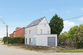 <p><span>In het rustige Hombeek, in een landelijke omgeving met weinig verkeer, bevindt zich deze prachtige nieuwbouwwoning in open bebouwing, die momenteel in de laatste afwerkingsfase verkeert en wordt verkocht onder het btw-stelsel van 21%, zonder opsplitsing tussen grond- en constructiewaarde. In de mooi afgewerkte garage is plaats voor één wagen, met bijkomende ruimte voor fietsen/motor. Technisch omvat deze hyper-geïsoleerde woning: algemene vloerverwarming (excl. garage), warmtepomp (8 kW) met boiler (190 l), 8 zonnepanelen met hybride omvormer, ventilatiesysteem D, grijze aluramen en zeer prijzige gevelstenen (Olivier Karma White Grey en White HV in waalformaat). Inkomhal, living en keuken vloeien quasi naadloos in mekaar. Bezoekers zullen oog hebben voor binnendeuren met verborgen scharnieren, grote keramische vloertegels, teleruptoren (schakelaars), plus trappen in wit composietmateriaal. De hoogwaardige maatkeuken valt op door greeploze kasten, diepe laden, composiet werkblad en volgende apparaten: kookplaat met geïntegreerde centrale afzuiging, grote inbouwkoelkast, diepvriezer, microgolfoven, conventionele oven en geïntegreerde vaatwasser. Op de eerste verdieping omvat de badkamer een ruime inloopdouche met glazen scheidingswand,  een dubbel badkamermeubel met dubbele wastafel en hangtoilet. Afgezien van de drie gelijkwaardige kamers op de eerste verdieping, staat nog bijna de gehele verdieping onder dak, op de ruime nachthall na, ter beschikking als vierde kamer met dakvlakramen van Velux.</span></p>