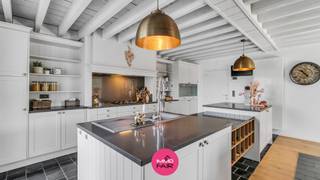 In Bilzen, meer bepaald in het rustige en landelijke Waltwilder, bevindt zich deze unieke vrijstaande villa op een royaal perceel van 22a. Je woont hier groen en rustig, maar zeker niet afgelegen: het centrum van Bilzen, Maastricht en de omliggende gemeenten zijn vlot bereikbaar.<br /><br />De woning werd gebouwd in 2014 en biedt circa 184 m² woonplezier. Wat meteen opvalt, is de warme uitstraling van de woning. De hoge plafonds, zichtbare houten dakconstructies, natuurlijke materialen en grote raampartijen zorgen voor veel licht en een aangename sfeer. Samen met de tuin, het zwembad en de verschillende terrassen krijgt deze woning een zuiderse toets met duidelijke Ibiza-vibes.<br /><br />De inkomhal met gastentoilet brengt je naar de open leefruimte, waar zithoek, eetruimte en leefkeuken mooi op elkaar aansluiten. De leefruimte geniet van veel lichtinval en een mooi zicht naar buiten. De keuken staat rechtstreeks in verbinding met de terrassen en de tuin, waardoor het buitenleven hier sterk aanwezig is.<br /><br />Op het gelijkvloers bevindt zich een ruime slaapkamer van ca. 20 m². Verder is er op de benedenverdieping een ruime wasruimte/berging: ideaal als wasplaats en technische ruimte.<br /><br />Op de verdieping bevinden zich twee ruime slaapkamers. De master bedroom heeft een oppervlakte van ca. 23 m². De tweede slaapkamer heeft een oppervlakte van ca. 19 m² en beschikt over een ruime aansluitende inloopdressing. De badkamer is ingericht met een ligbad, inloopdouche, dubbele wastafel en toilet.<br /><br />De buitenruimte werd met veel aandacht voor sfeer en comfort aangelegd. Rond het zwembad zijn verschillende terrassen en zithoekjes voorzien, zowel in de zon als onder de overkapping. De tuin is onderhoudsvriendelijk ingericht en biedt meerdere schaduwplekjes waar je op warme dagen aangenaam kan zitten. Je geniet hier ten volle van privacy en de groene omgeving. <br /><br />Het zwembad heeft een afmeting van ca. 10 m x 4 m en is uitgerust met een zoutfiltersysteem. Dankzij de verwarming via warmtepomp kan je hier extra lang genieten van het buitenleven.<br /><br />Aansluitend aan het perceel bevindt zich een weide, wat deze eigendom bijzonder interessant maakt voor paardenliefhebbers of voor wie graag extra ruimte rondom zich heeft. Daarnaast beschikt de woning over een carport voor 2 wagens en een ruime tuinberging.<br /><br />Ook technisch is deze woning goed uitgerust: het beschikt over een EPC-label A met een energiescore van 99 kWh/m²/jaar. De zonnepaneleninstallatie bestaat uit 29 panelen van 450 Wp, goed voor een totaal vermogen van 13.050 Wp. Deze installatie wordt gecombineerd met een Enphase thuisbatterij van 10,02 kWh. Verder beschikt de woning over airconditioning en verwarming op aardgas.<br /><br />Extra troeven:<br /><br />- Rustige ligging in Bilzen, deelgemeente Waltwilder<br />- Perceel van 22a 26ca met aansluitende weide<br />- Vrijstaande villa met ca. 184 m² woonplezier<br />- EPC-label A en zonnepanelen met thuisbatterij<br />- 3 ruime slaapkamers, waarvan 1 op het gelijkvloers<br />- Zwembad met zoutfiltersysteem en warmtepomp<br />- Onderhoudsvriendelijke tuin met terrassen, overkapping en schaduwplekjes<br />- Carport voor 2 wagens en ruime tuinberging<br /><br /><br />Op zoek naar een karaktervolle woning met zwembad en Ibizavibes? Contacteer ons voor meer informatie of een bezoek ter plaatse via 089 390 990 of info@immofair.be.