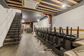 In het centrum van Sint-Niklaas, aan het Apostelplein, bevindt zich dit handelspand met woonst, geschikt voor diverse horeca- en handelsactiviteiten. De ligging in een levendige buurt zorgt voor een aangename passage en een vlotte bereikbaarheid, op wandelafstand van winkels, openbaar vervoer en het stadscentrum.
De handelsruimte is praktisch ingericht en beschikt over een ruime toog en voldoende sanitaire voorzieningen, wat het pand geschikt maakt voor café-, bistro- of andere horecaconcepten. Daarnaast zijn er een gezellig zonneterras en een bijkomend dakterras, wat een duidelijke meerwaarde biedt voor klanten.
Op de verdiepingen bevinden zich drie slaapkamers, een zolder en extra bergruimte, ideaal voor wie wonen en werken wenst te combineren. Het gebouw heeft een betonnen structuur en is voorzien van dakisolatie en dubbele beglazing. Verwarming gebeurt via gas en een warmtepomp met twee binnenunits.
Met een totale oppervlakte van circa 151 m² is dit pand interessant voor eigen uitbating of investering op een centrale locatie. Bel ons nu voor een afspraak op het nummer: 052/46.38.03 en wie weet tot binnenkort! 
