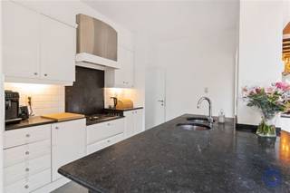 <p><span>Informatie Appartement</span></p><p><span>Dit uitzonderlijk ruim gelijkvloers appartement combineert comfort, karakter en een uiterst vlotte ligging. De leefruimte van ca. 46 m² bestaat uit twee gezellige zithoeken met twee werkende haarden, parketvloer en authentieke plafondbalken. Aansluitend bevindt zich de lichtrijke eetkamer met grote lichtstraat, die naadloos overgaat in de open keuken en de tuin. De volledig uitgeruste keuken beschikt over een dubbele koelkast (koel/vries/ijsfunctie), Miele-oven, groot kookeiland met granieten werkblad en ontbijttoog, gasvuur, vaatwasser en dubbele lavabo. Via de nachthal bereikt u drie ruime slaapkamers, waaronder een master bedroom (± 19 m²) met zicht op de tuin. Verder zijn er een grote badkamer met inloop-(regen)douche, toilet, lavabomeubel en wasmachineaansluiting, een apart toilet en een kleine koer. Buiten geniet u van een aangelegde tuin met vijver, terras en speeltuin. Extra troeven zijn de dubbele garage van ca. 125m² met 2 automatische poorten, individuele thermostaten per ruimte, geen maandelijkse kosten, individuele meters, EPC C, conforme elektrische keuring en asbestveilig attest. Het gebouw werd de voorbije jaren volledig gerenoveerd, inclusief een geïsoleerd dak conform 2050-normen, en beschikt over een videofoon. Ideale ligging voor wie veel onderweg is, met winkels, scholen en voorzieningen vlakbij.</span></p><p><span> </span></p><p><span>Indeling</span></p><ul><li><span>Zeer ruime woonkamer (± 46 m²), bestaande uit twee aparte zithoeken, elk voorzien van een prachtige, werkende haard. De ruimte is afgewerkt met een parketvloer en authentieke, goed bewaarde plafondbalken.</span></li><li><span>Eetkamer op parketvloer, een bijzonder lichtrijke ruimte dankzij de grote lichtstraat. Deze sluit naadloos aan op de tuin en de open keuken.</span></li><li><span>Zeer ruime keuken op tegelvloer, volledig uitgerust met: dubbele koelkast (koel-, vries- en ijsfunctie), Miele-oven, groot kookeiland met granieten werkblad en ontbijttoog, dubbele lavabo, vaatwasser, ruim aanrecht met gasvuur.</span></li><li><span>Aangelegde tuin met vijver en speeltuin voor kinderen, evenals een gezellig terras.</span></li><li><span>Via de nachthal heeft u toegang tot drie ruime slaapkamers, de badkamer en een apart toilet.</span></li><li><span>Master bedroom (± 19 m²), rustig gelegen aan de achterzijde van het appartement met zicht op de tuin.</span></li><li><span>Kleine koer, toegankelijk via de nachthal.</span></li><li><span>Tweede slaapkamer (± 14 m²), voorzien van een rolluik.</span></li><li><span>Grote badkamer op tegelvloer, uitgerust met een lavabomeubel met spiegelkast, toilet, inloop-(regen)douche, droogrek en aansluiting voor een wasmachine.</span></li><li><span>Derde slaapkamer (± 14 m²) aan de straatzijde, voorzien van automatische rolluiken.</span></li></ul><p><span> </span></p><p><span>Extra's</span></p><ul><li><span>Elke afsluitbare ruimte is uitgerust met een individuele thermostaat voor optimale klimaatregeling, ook instelbaar via een applicatie.</span></li><li><span>Slot inkomdeur kan vanop afstand bediend worden via WI-FI.</span></li><li><span>Dubbele garage met een totale oppervlakte van ca. 125 m², voorzien van 2 automatische poorten.</span></li></ul><p><span> </span></p><p><span>Algemene Informatie</span></p><ul><li><span>Maandelijkse kosten: geen (mede-eigenaars staan zelf in voor verzekering en onderhoud van hun deel van de gemeenschappelijke delen).</span></li><li><span>Individuele meters voor water, elektriciteit en gas.</span></li><li><span> </span></li></ul><ul><li><span>EPC: label C.</span></li><li><span>Elektrische keuring: conform AREI.</span></li><li><span>Asbestattest: asbestveilig.</span></li></ul><p><span>Gebouw</span></p><ul><li><span>Een kelderverdieping met garages, een gelijkvloers appartement met tuin, vier appartementen verdeeld over twee verdiepingen.</span></li><li><span>De linkse garage behoort volgens de basisakte tot de gemeenschappelijke delen, maar er werd met de mede-eigenaars overeengekomen dat deze eeuwigdurend privatief toebehoort aan het gelijkvloerse appartement.</span></li><li><span>Het volledige gebouw werd de voorbije jaren grondig gerenoveerd en verkeert in uitstekende staat.</span></li><li><span>Het dak werd vernieuwd en geïsoleerd conform de 2050-normen.</span></li><li><span>Videofoon aanwezig.</span></li></ul><p><span> </span></p><p><span>Ligging</span></p><ul><li><span>Ideale ligging voor iemand die veel op de baan moet!</span></li><li><span>Verschillende winkels, supermarkten en scholen in de omgeving.</span></li><li><span>Mobiscore: 9,0/10, een absolute topligging voor wie stedelijk en comfortabel wil wonen.</span></li></ul><p><span> </span></p><p><span>*De informatie in deze prospect is ter informatieve titel: de kandidaat-kopers moeten hun eigen zaak maken van het verkrijgen, controleren en interpreteren van deze informatie.</span></p><p><span> </span></p>