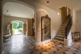 Dans l'une des plus belles rues de la résidence d'Oud-Turnhout, se trouve cette élégante maison de campagne Kempisch conçue par l'architecte Rutten. Ce petit bijou a été créé de manière particulière : d'abord les espaces intérieurs ont été conçus, puis les façades ont été dessinées. En procédant ainsi, une villa unique avec une disposition idéale a été créée. Dans toute la villa, une atmosphère de château sobre a été choisie. Une cheminée antique, des planchers en chêne, des dalles bourguignonnes antiques en différents motifs de pose (2ème couche), ainsi que des murs, des portes hautes, des placards, une bibliothèque et des volets en bois massif. Cela dégage tellement de chaleur et de tranquillité qu'il ne reste plus qu'à ajouter peu de meubles.<br /><br />La découverte de cette propriété commence en entrant sur le domaine de plus de 5 400 m². Arriver ici vous donne l'impression d'être le bienvenu.<br /><br />Rez-de-chaussée :<br />La villa a été conçue autour d'un hall d'entrée central avec vestiaire, toilettes invités et accès à la charmante cave à vin et à provisions. Une grande baie vitrée offre une vue magnifique sur le jardin arrière aménagé par un architecte paysagiste. À gauche de la villa se trouvent la cuisine, l'orangerie, la buanderie, un double garage et un carport fermé. La grande cuisine a été conçue sur mesure par un spécialiste de l'intérieur. Ici, l'atmosphère d'autrefois est recréée et le confort d'aujourd'hui est ajouté comme s'il s'agissait d'une seule et même chose. Cette cuisine avec un grand îlot de travail est équipée d'appareils intégrés élégants, dont la vedette est la fantastique cuisinière Lacanche. Le côté droit de la villa comprend le salon avec 2 coins salon, dont un avec une cheminée avec une cheminée antique. Adjacent, une belle bibliothèque entièrement lambrissée en chêne. Cette pièce multifonctionnelle s'intègre parfaitement au salon et offre diverses possibilités comme salon supplémentaire, salle de télévision ou de jeu pour les enfants, salle de lecture, etc. Un espace de bureau fermé avec toilettes est accessible depuis la bibliothèque, mais il est également accessible par une entrée séparée. Ici, vous pouvez travailler en toute tranquillité et profiter d'une belle vue sur le jardin.<br /><br />Premier étage :<br />L'escalier majestueux en pierre naturelle vous mène au premier étage. Cet étage peut être complètement fermé avec une porte blindée sous alarme.<br /><br />À l'étage, nous trouvons la chambre principale composée de la première salle de dressing, d'une chambre à coucher, de toilettes séparées, de la deuxième salle de dressing avec un grand dressing et d'une magnifique salle de bain ouverte jusqu'au faîte avec une grande baignoire, un double lavabo et une grande douche à l'italienne avec des mosaïques. Les chambres pour enfants et invités se trouvent à l'autre extrémité de la villa. Ici, nous trouvons 3 chambres avec chacune leur propre salle de bain finie en pierre naturelle avec douche, lavabo et placard intégré. Un escalier mène au deuxième étage depuis le couloir de nuit avec toilettes.<br /><br />Deuxième étage :<br />Ce deuxième étage comprend une chambre supplémentaire avec des placards intégrés, ouverte jusqu'au faîte, un grenier avec la possibilité de créer une 6ème chambre et une salle technique. Nous trouvons ici également un sauna spacieux "Klafs" et un banc d'assise intégré confortable.<br /><br />Dépendance :<br />Non seulement la villa offre chaleur, tranquillité et espace, mais aussi la dépendance unique de 95 m² dans le jardin a été créée avec autant de passion, de temps et d'attention. Ce petit bijou a été positionné au centre du magnifique jardin aménagé par un architecte paysagiste dans le même style de construction. Grâce aux fenêtres en