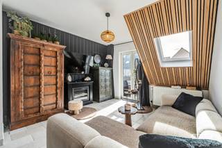 Op een gunstige ligging in de De Smet de Naeyerlaan vinden we dit gezellige duplex-appartement, gelegen op de 4de verdieping van een verzorgde residentie met lift. Bij het betreden van het appartement komen we terecht in een aangename leefruimte en een aanpalende keuken. De keuken werd reeds vernieuwd en is uitgerust met alle nodige toestellen. Op dezelfde verdieping bevindt zich een praktische berging met aansluitingen voor zowel een wasmachine als een droogkast. Verder is er op dit niveau een gastentoilet aanwezig alsook nog een ruime overloop die eventueel kan worden ingericht als slaaphoek of bijvoorbeeld een bureau.<br /><br />Via de hal bereiken we de bovenverdieping. Hier vinden we de slaapkamer, een recent gerenoveerde badkamer en een afzonderlijk toilet. <br /><br />Het appartement wordt verwarmd via centrale verwarming op aardgas. De verwarmingsketel werd recent vernieuwd. De elektrische installatie werd gekeurd en is conform. Als extra troef beschikt de residentie over een fietsenberging.<br /><br />Stedenbouwkundige inlichtingen zijn in aanvraag. <br /><br />