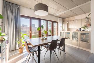Op een toplocatie op het Antwerpse Eilandje bevindt zich dit uitzonderlijk loftappartement in een karaktervol brutalistisch gebouw. Het zichtbare betonnen plafond geeft het interieur een krachtige, architecturale uitstraling die perfect samengaat met de strakke lijnen en het overvloedige natuurlijke licht.<br /><br />Het appartement is energetisch doordacht gebouwd en biedt een uiterst flexibel grondplan: alles kan perfect als één open, loftachtige ruimte worden ingericht. De volledig geïnstalleerde keuken sluit naadloos aan op de eetkamer en woonkamer, die samen genieten van een prachtig zicht op het water — een dagelijks gevoel van rust en ruimte.<br /><br />Ruime slaapkamer en badkamer met ligbad en douche. Gezellig terrasje met namiddag en avondzon!<br /><br />Parking faciliteit in de buurt.