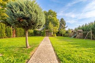 A rare property for its volumes, its character and its possibilities.
In Lembeek, part of Halle, this remarkable late-19th-century mansion house offers approx. 571 m² of living space on a plot of 19a 54ca (1,954 m²).
Fully renovated in 2014, the house has retained many of the features that give it its charm: marble mosaic, blue stone, oak parquet, solid plank floors, high ceilings and marble fireplaces.
With 8 bedrooms, 2 bathrooms, a shower room, 2 kitchens and 4 levels, the property offers a wealth of options: a large family home, multigenerational living, space for a home practice, or a house in which a self-contained unit can be created as needed.
GROUND FLOOR
Spacious entrance hall with original mosaic floor and period staircase. To the right, the dining room with wood stove, leading into the fitted kitchen: SMEG range cooker, induction hob, two ovens and dishwasher. To the left, a very large two-part living room, filled with light from wide windows, with two wood stoves in marble fireplaces.
FIRST AND SECOND FLOORS
Four large rooms and a bathroom on each floor, free to arrange as you wish: bedrooms, study, dressing room or playroom. Throughout: high ceilings, preserved marble fireplaces, wooden floors and green views. Air conditioning on this level.
LOWER LEVEL, OPENING ONTO THE GARDEN
With its direct access at the rear, this level works as a separate living unit: a large fitted kitchen with wood stove, an additional room, a shower room with separate WC, a laundry room, a plant room and several dry storage cellars.
GARDEN AND PARKING
Almost 20 ares, fully landscaped: a wide cobbled terrace along the house, a large lawn, mature trees, a garden pavilion and a fixed play area. Cobbled driveway at the front, two entrance gates, a property that can be fully closed off and parking for several cars.
TECHNICAL
Complete renovation in 2014 and windows replaced in 2018. Gas central heating with condensing boiler throughout the house; the wood stoves are an extra for atmosphere and additional warmth. Domestic hot water from a solar water heater (4.8 m² of collectors).
LOCATION
Lembeek (Halle): bus stop and shops within walking distance, quick access to the town centre, the station, Brussels and the E19/R0. Schools and childcare nearby.
This property truly reveals itself on a visit. Call 0486 13 12 70 or email oliva.claes@claeswillems.be.