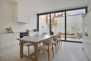 <p><span>In de statige Delportestraat, midden in het centrum van Tienen, bevindt zich deze karaktervolle herenwoning die in 2026 volledig werd gerenoveerd. Met drie slaapkamers, twee badkamers, een dressing, royale plafondhoogtes en EPC-label A combineert ze authentieke charme met het comfort van vandaag.</span></p>
<p><strong><span>Indeling</span></strong></p>
<p><span>Via de ruime inkomhal met vestiaire, gastentoilet en afzonderlijke wasplaats betreden we het gelijkvloers, waar de grote ramen en plafondhoogtes van meer dan drie meter voor een bijzonder ruimtelijk gevoel zorgen. Aan de voorzijde bevindt zich de leefruimte met parketvloer, terwijl de leefkeuken achteraan rechtstreeks aansluit op de onderhoudsvriendelijke stadstuin.</span></p>
<p><span>De keuken werd afgewerkt met grootformaattegels (90 × 90 cm) en beschikt over een composiet werkblad, hoogwaardige inbouwtoestellen en een wijnkoeler. De brede glaspartij zorgt voor een overvloed aan natuurlijk licht en kan voor twee derde worden opengeschoven, waardoor binnen en buiten op zonnige dagen naadloos in elkaar overlopen.</span></p>
<p><span>De eerste verdieping omvat een ruime slaapkamer met dressing, een badkamer met ligbad en douche en een apart toilet. De dressing is ruim genoeg om eventueel dienst te doen als extra kinderkamer of bureau. Op de tweede verdieping bevinden zich twee bijkomende slaapkamers met zicht op de authentieke dakbalken, evenals een tweede badkamer met douche en toilet. </span></p>
<p><span>De droge kelder biedt bijkomende bergruimte. De aanwezige verlichting zal blijven hangen en is inbegrepen in de verkoopprijs.</span></p>
<p><strong><span>Energie en comfort</span></strong></p>
<p><span>Bij de totaalrenovatie werd veel aandacht besteed aan energiezuinigheid, met onder meer bijkomende isolatie, driedubbele beglazing, vloerverwarming op het gelijkvloers en acht zonnepanelen (3.720 Wp). Het resultaat is een uitstekend EPC-label A, met een energiescore van slechts 68 kWh/m² per jaar.</span></p>
<p><strong><span>Omgeving</span></strong></p>
<p><span>De Leuvensestraat, een van de voornaamste winkelstraten van Tienen, ligt op amper 100 meter. Ook het station bevindt zich op slechts vijf minuten wandelen. Winkels, horeca en andere dagelijkse voorzieningen liggen met andere woorden binnen handbereik.</span></p>
<p><span>Tot slot is er de mogelijkheid om een autostaanplaats in de Delportestraat afzonderlijk te huren voor €68 per maand. De verkopers voorzien in de overdracht van het huurcontract aan de koper.</span></p>
<p><strong><span>Ontdek deze instapklare herenwoning tijdens een bezoek.</span></strong><span> Contacteer Jonas van Dhumas via 0491 29 53 92 of </span><span>jonas@dhumas.be</span><span>.</span></p>