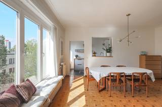 Wonen op de bovenste verdieping brengt alleen maar voordelen met zich mee. Geen bovenburen, veel natuurlijke lichtinval en een aangenaam gevoel van rust. Dit appartement op de 4e verdieping aan de C. Huysmanslaan combineert het karakter van een oerdegelijk gebouw in de stijl van ‘58, met het hedendaagse wooncomfort dat je vandaag zoekt.<br /><br />Je komt binnen in een ruime hal, waar meteen de originele parketvloer opvalt. Ook de leefruimte geniet van de charme van originele elementen die in ere zijn gehouden bij renovatiewerken. De halfopen keuken sluit mooi aan op de woonkamer en zorgt voor een open, gezellige indeling. De badkamer werd volledig vernieuwd en is afgewerkt in een tijdloze, moderne stijl. Daarnaast is er een aparte berging voorzien voor de wasmachine en extra voorraad.<br />Het appartement beschikt over twee volwaardige slaapkamers die tal van mogelijkheden bieden - een thuiskantoor of een kinderkamer. Achteraan geeft de 2e slaapkamer uit op een klein zonnig terras.<br /><br />Ook praktisch scoort dit appartement goed. In de kelder beschik je over een privatieve berging, ideaal voor fietsen, koffers of seizoensmateriaal.<br />De buitenruimte op het gelijkvloers mag ook gebruikt worden voor het plaatsen van een fiets voor dagelijks gebruik.<br /><br />Met een EPC-label B ben je bovendien verzekerd van een energiezuinige woning, zonder dat er nog ingrijpende renovatiewerken nodig zijn.<br /><br />Een lichtrijk en verzorgd appartement met authentieke elementen, een doordachte indeling en een instap klaar karakter. Interesse? We tonen het je graag!<br />Vg, Wg, Gmo, Gvkr, Gvv, geen overstromingsgevoelig gebied