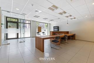 Voor meer info en foto’s, surf naar www.swevers.be – Op een toplocatie aan de Thonissenlaan 114 in Hasselt bevindt zich deze ruime kantoorruimte van ca. 333 m². Dankzij de ligging langs de kleine ring geniet het pand van een uitstekende bereikbaarheid én uitzonderlijke zichtbaarheid. Een extra troef zijn de twee grote vitrines, één aan de Thonissenlaan en één aan de Kempische Steenweg, waardoor uw onderneming zichtbaar is op twee strategische locaties. Het pand, opgericht in 2005, beschikt over een functionele indeling met een aparte inkom en ruime onthaalruimte die een professionele eerste indruk creëert. Verder zijn er meerdere bergingen, drie afzonderlijke bureauruimtes, een grote open kantoorruimte en een ruime vergaderzaal. Hierdoor biedt het pand tal van mogelijkheden voor uiteenlopende bedrijfsactiviteiten. Daarnaast beschikt het kantoor over een ingerichte keuken van ca. 9,5 m², twee afzonderlijke toiletten en een praktische opslagruimte van ongeveer 21,4 m². De combinatie van individuele kantoren, open werkzones en ondersteunende ruimtes zorgt voor een efficiënte en aangename werkomgeving. De centrale ligging vormt een belangrijke meerwaarde. Openbaar vervoer bevindt zich op slechts 120 meter, de op- en afritten van de snelweg liggen op 2,2 kilometer en diverse winkels, restaurants en ontspanningsmogelijkheden bevinden zich in de onmiddellijke omgeving. Ook parkeergelegenheid is vlot bereikbaar. Bent u op zoek naar een representatieve kantoorruimte met een uitstekende ligging, veel zichtbaarheid en een doordachte indeling? Dan is dit pand een interessante opportuniteit voor uw onderneming. Voor meer informatie, bel 011 255 155. Bron bewoonbare oppervlakte: EPC – verslag.