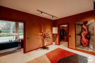 <p><span>Hippe seventies-villa in full retro vibe!</span></p><p><span> </span></p><p><span>Volledig in stijl gerenoveerd én ingericht—hier woon je gelijkvloers in pure 70’s sfeer, met een royale leefruimte vol gigantische raampartijen en heerlijk veel licht. Momenteel ingedeeld met 2 slaapkamers en 2 badkamers, een enorme zolderverdieping en een aansluitend bijgebouw met dubbele garage en atelier. Dit alles op een riant, zuidgericht perceel van ca. 4.700 m², in een rustige residentiële buurt vlak bij het centrum van Kapellen.</span></p><p><span> </span></p><p><span>Gelijkvloers</span></p><p><span>Binnenkomen doe je in een strakke inkomhal met gastentoilet. De leefruimte is één grote open, lichte cocon met uitzicht op het beukenbos. Dankzij de nieuwe doorkijkhaard ontstaat een cozy scheiding tussen zithoek en eetruimte. Aansluitend vind je de unieke, semi-open keuken—retro in look, modern in comfort.</span></p><p><span>De masterunit is pure luxe: een ruime slaapkamer met zicht op de tuin, volledig ingemaakte dressingkasten én een wellness-badkamer met sauna, ligbad, inloopdouche, toilet en dubbele lavabo. Daarnaast is er een aparte dressingruimte.</span></p><p><span>Aan de andere zijde van de inkom bevindt zich de tweede slaapkamer, eveneens met eigen inloopdouche en toegang tot een overdekt terras in de knusse binnentuin.</span></p><p><span> </span></p><p><span>Zolder</span></p><p><span>Via een vlizotrap kom je op een gigantische bergzolder over de volledige woning, met betonnen vloer. De centrale inkomhal biedt de mogelijkheid om een vaste trap te plaatsen—ideaal om deze etage om te toveren tot extra slaapkamers, hobbyruimte of home office.</span></p><p><span> </span></p><p><span>Bijgebouw</span></p><p><span>Het geschakelde bijgebouw (60 m2) herbergt een atelierruimte met aansluitingen voor de wasmachine en een dubbele garage.<br />Dit gebouw kan ook perfect dienen als kantoor, atelier of praktijkruimte aan huis.</span></p><p><span> </span></p><p><span>Tuin</span></p><p><span>Rondom de villa ligt een prachtige, zuidgerichte bostuin met volwassen beuken en veel privacy. Achteraan vind je een groot zonneterras. Tussen de woning en het bijgebouw vormt een afsluitende buitenmuur een sfeervolle binnentuin, een mediterrane patio vibe, maar dan in Kapellen.</span></p><p><span> </span></p><p><span>Bijzonderheden</span></p><p><span>- Originele 70’s villa, volledig in stijl opgefrist.</span></p><p><span>- De villa kenmerkt zicht door de grote raampartijen en de hoge plafondhoogte van meer dan 3 meter</span></p><p><span>- Topligging in een gegeerde residentiële wijk nabij het dorpscentrum.</span></p><p><span>- Zuidgerichte tuin met prachtige bomen.</span></p><p><span>- Grote zolderverdieping met talloze mogelijkheden.</span></p><p><span>- Gekoppeld bijgebouw, ideaal voor kantoor of praktijk aan huis<br />- Bewoonbaar oppervlakte van 278 m2 incl het bijgebouw (60 m2) en excl de zolder (ca. 160 m2).</span></p><p><span>- De living werd onder toezicht van de architect ingericht en mogelijk om mee aan te kopen. </span></p><p><span> </span></p><p><span> </span></p>