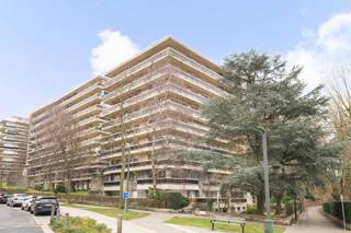In het hart van het gegeerde Parc Brugmann biedt dit hoekappartement op de 6e verdieping van een verzorgd gebouw uit de jaren 70 alles wat men zoekt in Brussel: licht, groen en ruimte.<br />Vanaf de inkomhal valt de helderheid meteen op. De grote raampartijen baden de parketwoonkamer van ±35 m² in natuurlijk licht en vormen een mooie overgang naar buiten. Momenteel staat de leefruimte open in verbinding met een derde slaapkamer of bureau, ideaal voor thuiswerk of een gezellige leeshoek. Met ±120 m² bewoonbare oppervlakte en vooral ±36 m² terrassen op het zuidwesten, leeft u hier van ’s morgens tot zonsondergang ook buiten. Het uitzicht is open, groen en rustgevend — een echte luxe in de stad.<br />De uitgeruste keuken, deels open te maken naar de leefruimte, zorgt voor een vlotte en aangename circulatie. Het nachtgedeelte omvat twee slaapkamers met buitentoegang en twee badkamers, wat uitzonderlijk comfort biedt voor zowel een gezin als gasten.<br />Binnenstaanplaats + kelder: praktisch in het dagelijks leven en bijzonder waardevol in de buurt. EPC C. Kosten: ± 375 €/maand (gemeenschappelijke kosten - exclusief verbruik) + 33 €/maand (reservefonds).<br />Een lichtrijk, ruim appartement omringd door groen, in een van de meest gegeerde woonomgevingen van Brussel. Een woning om te beleven, niet alleen om te bezoeken.<br />
<p><span>6e verdieping</span> : Lot Q3 – Blok III (aandelen: 75/10.000)</p>
<ul>
<li>Inkomhal met vestiaire</li>
<li>Toilet</li>
<li>Woonkamer op parket van ± 35 m² (momenteel samengevoegd met de 3e slaapkamer)</li>
<li>Toegang tot de zuidwestgerichte terrassen (± 36 m²)</li>
<li>Uitgeruste keuken van ± 13 m², deels open te maken</li>
<li>Nachthal</li>
<li>Slaapkamer van ± 15 m² op parket met buitentoegang</li>
<li>Slaapkamer van ± 11 m² op parket met buitentoegang</li>
<li>Badkamer (bad, douche, dubbele lavabo)</li>
<li>Badkamer (bad, lavabo)</li>
</ul>
<p><span>Gelijkvloers</span> : Kelder nr. 27</p>
<p><span>1e kelderverdieping</span> : Blok II (aandelen: 3/10.000) Binnenparkeerplaats nr. 156 (+ 25.000 €)</p>