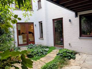 Op zoek naar een uitzonderlijke stadswoning met garage waar authentieke charme en hedendaags wooncomfort elkaar ontmoeten?<br /><br />Deze instapklare woning weet meteen te verrassen: bij het binnenstappen valt meteen de royale inkomhal op met als blikvanger de spiltrap rustend op natuursteen.<br /><br />De open, modern uitgeruste keuken vormt een mooi samenspel met de authentieke, eeuwenoude eiken balken die de ruimte karakter geven. Zowel de keuken als de eetkamer bieden een overvloed aan opbergruimte.<br /><br />Naast de sfeervolle woonkamer herbergt de eerste verdieping een aparte bureauruimte, een eigentijdse badkamer en twee van de drie slaapkamers.<br /><br />Op de zolderverdieping vindt u de derde slaapkamer en een extra ruimte, thans in gebruik als atelier; eenvoudig om te vormen tot een vierde slaapkamer of hobbyruimte.<br /><br />◆ OASE VAN RUST IN DE STAD ◆<br /><br />Vanuit de keuken wandelt u zo de gezellige, groen aangelegde stadstuin in. Het verhoogde terras met pergola nodigt uit om hier op elk moment van de dag te genieten: met de ochtendzon bij het ontbijt, in de schaduw tijdens de warme middaguren of beschut tegen een zomerse regenbui. <br /><br />◆ RUIME GARAGE ◆<br /><br />Hoewel de ruime garage in principe plaats biedt voor twee wagens, is hij in het bijzonder geschikt voor één wagen en kan de resterende ruimte benut worden voor fietsen en bergruimte.<br /><br />◆ PRINSENHOF, EEN DORP IN DE STAD ◆<br /><br />Het Prinsenhof behoort tot de meest karaktervolle woonbuurten van Gent. Je woont hier in een historische en rustige stadsomgeving, op wandelafstand van het centrum, met winkels, horeca, cultuur, scholen, diensten en openbaar vervoer in de onmiddellijke omgeving.<br /><br />De ligging combineert het beste van twee werelden: het bruisende stadsleven vlakbij, maar met het eigen karakter en de intimiteit van een echte woonbuurt.<br /><br />◆ MOBISCORE: 9,4/10 ◆<br /><br />De woning beschikt over een uitstekend aanbod aan openbaar vervoer. Onderwijs, winkels en diensten, ontspanning, sport en cultuur én gezondheidszorg zijn zeer goed bereikbaar te voet of met de fiets.<br /><br />