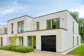Gelegen aan de Gentsesteenweg te Erondegem (Erpe-Mere) woon je hier bijzonder rustig én bijzonder vlot bereikbaar. De kleinschalige residentie 't Hemelsveld is zowel vooraan als achteraan omgeven door natuurgebied. Alle dagelijkse voorzieningen liggen in de onmiddellijke omgeving: bakker, slager, apotheek, grootwarenhuis, tankstation en horeca. De bushalte bevindt zich op 100m en de oprit van de E40 op 3 km.<br /><br />Deze moderne halfopen bebouwing van 20m diep en 7m breed telt ongeveer 236 m² woonoppervlakte op een perceel van circa 5a07ca, met een zuidgerichte tuin van 25 m diep. De woning werd gebouwd volgens de strengste normen inzake isolatie en ventilatie, en dat laat zich voelen: overvloedig licht, een uitgesproken ruimtegevoel en een opvallend akoestisch comfort dankzij de driedubbele beglazing.<br /><br />Op het gelijkvloers brengt de zij-inkom je in een zeer ruime leefruimte van 70m². De open keuken sluit aan op een praktische berging. Verder vind je hier een slaapkamer (of thuisbureau) met eigen badkamer, een apart gastentoilet en een inpandige garage. Het aansluitende terras is voorzien van een buitendouche en de aansluitingen voor een buitenkeuken, ideaal om in de zomermaanden volop buiten te leven.<br /><br />De verdieping telt drie bijkomende slaapkamers, een ruime badkamer, een apart toilet en een extra ruimte die zich uitstekend leent als dressing of bureau. Het hoogtepunt is de rechtstreekse toegang tot het zonneterras op de verdieping, met zicht op de tuin en het bos.<br />Voor de woning bevinden zich er nog 3 autostaanplaatsen.<br /><br />Technisch is deze woning uitzonderlijk doordacht. De combinatie van passiefbouw en zonnepanelen zorgt voor een aanzienlijk lager energieverbruik. Een regenwaterput van 10.000 liter met bijhorend zuiveringssysteem levert bijzonder zacht water, wat het verbruik van leidingwater sterk terugdringt. De driedubbele beglazing is zonwerend uitgevoerd.<br /><br />Troeven:<br />Zuidgerichte tuin van 25 m diep met meerdere terrassen<br />Ruime leefruimte van 70 m² met veel lichtinval<br />Driedubbele zonwerende beglazing <br />Regenwaterput van 10.000 l met zuiveringssysteem<br /><br />Bestuursmaatregelen in het maatregelenregister: nee