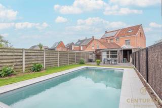 <p>Centraal gelegen halfopen bebouwing in <strong>uitstekende staat van onderhoud</strong>, die doorheen de jaren zorgvuldig werd gerenoveerd en geüpdatet. Deze ruime woning combineert comfort, functionaliteit en een aangename buitenbeleving. Voor de deur beschikt u over parkeergelegenheid, terwijl de <strong>automatische carport met plaats voor 2 wagens</strong> doorgang geeft naar de achterliggende tuin.</p>
<p>U betreedt de woning via de inkomhal met voldoende ruimte voor jassen en schoenen. De ruime woonkamer vormt een aangename leefruimte en sluit naadloos aan op de gezellige leefkeuken, die voorzien is van alle comfort, een eetplaats en een lichtrijke lichtstraat. Achter de keuken bevindt zich een knusse tv-hoek met zicht op het terras en het zwembad. Op het gelijkvloers vindt u eveneens een badkamer met inloopdouche, wastafel en toilet.</p>
<p>Op de eerste verdieping bevinden zich twee ruime slaapkamers en een verzorgde badkamer met ligbad, wastafel en toilet. De tweede verdieping biedt nog eens twee extra slaapkamers en een praktische bergruimte.</p>
<p>De tuin vormt een echte troef: fraai aangelegd met terrassen aan beide uiteinden, een recent geplaatst <strong>verwarmd zwembad met roldek</strong> en een royaal bijgebouw dat perfect kan dienen als werkhuis, mancave of hobbyruimte. Bovendien wordt er door de buur een mooie leilinde aangeplant, wat zorgt voor extra privacy en een groene omkadering.</p>
<p>Technisch is de woning volledig up-to-date: dak vernieuwd in 2017 met 14 cm isolatie, condensatieketel (2018), zonnepanelen (2018), airco (2023), verwarmd zwembad (2023) en een recente badkamer op het gelijkvloers (2025).</p>
<p>Kortom, een instapklare en bijzonder complete woning op een centrale ligging met alles wat u nodig heeft voor comfortabel wonen.<br /><br />Uw eigendom verkopen? Bel ons voor een gratis en vrijblijvende schatting via 014 48 12 21.</p>