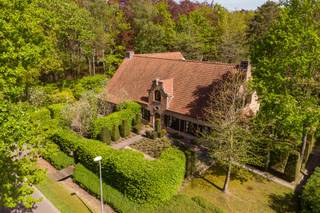 Gelegen in de gegeerde villawijk “De Lint” in Oud-Turnhout, geniet deze woning van een rustige en groene omgeving met een vlotte bereikbaarheid richting de E34 en nabijheid van scholen, winkels en openbaar vervoer.<br /><br />Deze villa met een bewoonbare oppervlakte van ca. 504 m² verwelkomt u via een ruime inkomhal met gastentoilet. De leefruimte sluit mooi aan op de volledig uitgeruste keuken en biedt een aangenaam zicht op de tuin. Op het gelijkvloers bevindt zich tevens een ruime slaapkamer met ensuite badkamer voorzien van douche, bad en toilet, wat het wooncomfort aanzienlijk verhoogt. Op de verdieping vindt u vier bijzonder ruime kamers die flexibel kunnen ingericht worden als extra slaapkamers, bureauruimtes, hobbykamers of zelfs voor kangoeroewonen. De woning beschikt bovendien over een volledig ingerichte wijnkelder waar liefhebbers in een sfeervolle setting hun collectie kunnen bewaren en genieten van een glasje wijn. Buiten geniet u van een ruime tuin met veel privacy en een overdekt terras waar het het hele jaar door aangenaam vertoeven is. De dubbele inpandige garage zorgt voor praktische parkeergelegenheid en extra bergruimte.<br /><br />De woning beschikt over een EPC-label C en valt niet onder de renovatieverplichting.<br /><br />Troeven:<br />• Rustige ligging in villawijk<br />• 6 ruime (slaap)kamers met diverse mogelijkheden<br />• Gelijkvloers wonen mogelijk<br />• Sfeervolle wijnkelder om te genieten van uw collectie<br />• Overdekt terras en privatieve tuin<br />• Asbestveilig