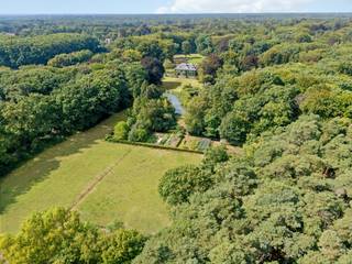 Te midden van een prachtig parklandschap, verscholen in rust en privacy, bevindt zich het uitzonderlijke domein Haezenveld te Kapellen. Oorspronkelijk gebouwd in 1938 door de grootvader van de huidige eigenaars, ademt dit eigendom een zeldzame combinatie van authenticiteit, elegantie en verfijnd wooncomfort.<br /><br />Het hart van het domein wordt gevormd door de prestigieuze villa. Een statige inkomhal leidt naar ruime ontvangstruimtes, waar hoogwaardige materialen zoals authentiek parket en sierlijke afwerkingen warmte en karakter brengen. De eetkamer met hoge plafonds en brede deuren, de prachtige bibliotheek met open haard en ingemaakte kasten, en het royale salon met meerdere zithoeken vormen samen een setting die zowel stijlvol als functioneel is.<br />Vanuit de villa geeft een overdekt terras zicht op de fraai aangelegde parktuin. Praktische voorzieningen zoals een keuken met aparte eethoek, wasplaats en kelders voor wijn en voorraad onderstrepen de doordachte indeling.<br />Op de eerste verdieping bevinden zich vier ruime slaapkamers, elk met verfijnde details en en-suite badkamers. Eén kamer beschikt bovendien over een open haard en balkon. Aanvullend zijn er drie kinderkamers en een hobbyruimte, eveneens bereikbaar via een buitentrap. De zolderverdieping biedt bijkomende kamers; logeerruimtes, personeelsvertrekken of bergruimtes.<br /><br />Naast de hoofdvilla maakt een gerenoveerde conciërgewoning (2019) (deels verhuurd) deel uit van het domein, aangevuld met drie garages, stallen en bergruimtes. <br /><br />Een domein met uitstraling:<br />De omgeving van de villa is adembenemend. De vijver, Franse tuin, eeuwenoude bomen en uitgestrekte weilanden creëren een sfeer van rust en harmonie. <br />Het domein beschikt daarnaast over een te renoveren zwembad en tennisveld, evenals een moestuin met bijhorende kassen.<br /><br />De essentie van exclusiviteit:<br />Haezenveld is een uitzonderlijk eigendom dat klassieke elegantie koppelt aan hedendaags comfort. Het domein straalt discretie, grandeur en authenticiteit uit en behoort daarmee tot de meest bijzondere residenties van Noord-Antwerpen.<br /><br />Haezenveld is een levend kunstwerk; een schilderij waarin perspectieven en kleuren mee veranderen met de uren van de dag en de seizoenen. Paarden, schapen, zwanen, wilde eenden, reeën en talloze vogels maken deel uit van het decor. Muren die begroeid zijn met een meer dan tachtig jaar oude wilde wijnstok versterken de authenticiteit. <br />Enkel natuur, stilte, wooncomfort en discretie omarmen dit domein<br /><br />Buitengewone kenmerken:<br />Landgoed van ca. 100.000m²<br />Privatieve oprijlaan<br />Parking voor 10 wagens<br />Villa Haezenveld, Conciërgewoning (2019), garages (plaats voor 5 wagens), <br />Park met vijver, eeuwenoude bomen, rododendrons, gazons en bospercelen<br />Vier weiden voor paarden en schapen<br />Moestuin met serre voor bloemen, groenten en fruit<br />Zwembad en tennisbaan (te renoveren)<br />Absolute rust en volledige privacy, zonder zichtbare buren of geluidsoverlast<br />Goede bereikbaarheid, open baar vervoer, scholen, winkels in de omgeving.