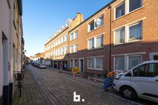 Dit duplex appartement is centraal gelegen in een rustige zijstraat van de Langestraat, net buiten het kloppend hart van centrum Brugge. De indeling is als volgt: inkom, gastentoilet, woonkamer, aparte keuken met aanpalend terras, berging/wasplaats, 1 slaapkamer. Op het verdiep: 2 slaapkamers waarvan één met grote inbouwkast, badkamer (douche, 2 wastafels, toilet). Inclusief privé (fietsen)berging achteraan het gebouw. Het appartement is op heden verhuurd aan een correcte huurder. Mogelijkheid tot aankoop van een autostaanplaats achteraan het gebouw.