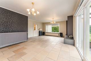 Deze goed onderhouden bungalow uit <strong>1977</strong> ligt in een rustige wijk nabij <strong>het centrum</strong>. De woning blinkt uit in haar praktische indeling en werd altijd met de grootste zorg onderhouden. Met een <strong>bewoonbare oppervlakte van 152 m²</strong> bevindt het volledige leefcomfort zich op het gelijkvloers, aangevuld met een handige eerste verdieping.<br /><br /><strong>Indeling en troeven:</strong>
<ul>
<li><strong>Gelijkvloers:</strong> Inkomhal met gastentoilet en een <strong>natuurstenen vloer </strong>die doorloopt in de keuken en de leefruimte met gezellige houtcassette. De zithoek en keuken (met fornuis, oven, frigo en vaatwas) sluiten aan op de veranda, die toegang geeft tot <strong>het zonnige terras</strong> <strong>en de tuin</strong>. Verder zijn er <strong>3 slaapkamers</strong> (in laminaat) en een badkamer met ligbad, dubbele lavabo en een tweede toilet.</li>
<li><strong>Eerste verdieping: </strong>Bereikbaar via een vaste trap en al voorzien van <strong>vernieuwde Velux-ramen</strong>. Deze ruimte onder het dak is ideaal te gebruiken als logeerkamer, hobbyruimte of extra berging.</li>
<li><strong>Garage: Dubbele garage</strong> met automatische poort en een handige regenwaterpomp.</li>
</ul>
<br /><strong>Technisch:</strong>
<ul>
<li><strong>Elektriciteit:</strong> Volledig <strong>conform!</strong></li>
<li><strong>Ramen:</strong> Grotendeels vernieuwd in <strong>PVC (2010) </strong>met rolluiken in de slaapkamers. Vernieuwde leidingen (badkamer & gastentoilet). Centrale verwarming op mazout.</li>
<li><strong>Renovatieplicht:</strong> Onderhevig aan de Vlaamse renovatieplicht (voornamelijk door het ontbreken van dakisolatie) — de ideale kans om meteen te isoleren naar eigen wens en te besparen op je energiefactuur.</li>
</ul>
<strong>Kortom, een solide en comfortabele thuis met enorm veel potentieel! Plan snel je bezoek en ontdek zelf alle troeven.</strong>