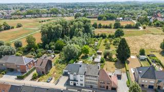 Deze verzorgde woning met praktijkruimte biedt maar liefst 471 m² bewoonbare oppervlakte. Door de jaren heen werd het pand consequent onderhouden en vernieuwd, wat resulteert in het stijlvolle en lichtrijke interieur dat de woning vandaag kenmerkt. Achteraan strekt zich een groene, volledig omhaagde tuin uit met zwemvijver en ruim zonneterras, geheel aan het zicht onttrokken, voor maximale rust en privacy. Zowel binnen als buiten valt de uitzonderlijke stilte meteen op.<br /><br />Op het gelijkvloers geeft een aparte ingang toegang tot een gastentoilet, een ruime wachtkamer en een verzorgde praktijkruimte met douchecabine. Verder vindt u hier een groot bureau, meerdere bergingen en een trap naar de opslagkelder. Via een andere deur betreedt u de private inkomhal met de trap naar de eerste verdieping.<br /><br />Op de eerste verdieping bevindt zich de gezellige leefruimte, opgedeeld in een eetkamer, salon en zithoek, en verwarmd door een sfeervolle houthaard. De open geïnstalleerde keuken sluit hier naadloos bij aan. Vanuit de leefruimte hebt u rechtstreeks toegang tot het zonneterras op het verdiep. Een apart toilet en een berging vervolledigen deze verdieping.<br /><br />De tweede verdieping telt drie ruime slaapkamers, een aparte dressing en een luxueuze badkamer met inloopdouche, ligbad en lavabomeubel.<br /><br />De tuin telt tal van gezellige plekjes om tot rust te komen en van het groen te genieten. Enkele jaren geleden werd er een schitterende zwemvijver aangelegd, die het geheel een echte vakantiesfeer geeft. Uw wagens parkeert u in de dubbele garage, uitgerust met laadpaal. Op het dak liggen zonnepanelen.<br /><br />Deze woning combineert wooncomfort, professionele mogelijkheden en een uitzonderlijk aangename buitenruimte.<br /><br /><br /><br />Bestuursmaatregelen in het maatregelenregister: nee