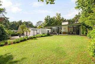Op een absolute toplocatie in het groene Poppel, verscholen in een rustige residentiële omgeving en grenzend aan de natuur, bevindt zich deze uitzonderlijke architecturale villa. Een eigendom waar luxe, privacy, ruimte en verfijning op harmonieuze wijze samenkomen. Dankzij de doordachte architectuur, hoogwaardige materialen en de naadloze verbinding tussen binnen- en buitenruimtes geniet u hier elke dag van een exclusieve woonbeleving.<br /><br />Bij het betreden van de woning wordt u verwelkomd in een inkomhal met vestiaire en een apart gastentoilet. Vanuit deze royale entree bereikt u zowel de leefruimtes als, via een stijlvolle glazen doorgang, de afzonderlijke slaapvleugel.<br /><br />De bijzonder lichtrijke leefruimte vormt het hart van de woning. Grote glaspartijen brengen het omliggende groen naar binnen en creëren een unieke interactie tussen de woning, de Japanse binnentuin en het zwembad. De sfeervolle gashaard zorgt voor warmte en gezelligheid, terwijl één van de raampartijen is uitgevoerd in innovatief schakelbaar glas voor extra comfort op zonnige dagen.<br /><br />De hypermoderne leefkeuken werd in 2023 verder geoptimaliseerd met een Liebherr Fresh-koelkast, Siemens inductiekookplaat en combi-oven, een Miele vaatwasser en een Quooker. De maatwerkkasten en de praktische bijkeuken maken het geheel compleet.<br /><br />Ook het souterrain werd ingericht met oog voor ontspanning en functionaliteit. Hier bevinden zich een ruime homecinema, een volledig ingerichte fitnessruimte, een technische ruimte en een royale inpandige garage voor twee wagens. Indien gewenst kan de fitnessruimte opnieuw bij de garage worden betrokken, waardoor plaats ontstaat voor een derde wagen. Daarnaast beschikt de woning over parkeergelegenheid voor maar liefst negen bezoekerswagens.<br /><br />Via de volledig beglaasde doorgang, met zicht op de sfeervol verlichte Japanse binnentuin, bereikt u de slaapvleugel. De master suite beschikt over een royale slaapkamer en een smaakvol vernieuwde badkamer (2019), uitgerust met een ligbad, dubbele wastafel en een exclusieve Sunshower met keuze tussen infraroodwarmte of UV-licht.<br /><br />Daarnaast zijn er nog twee ruime slaapkamers en een tweede badkamer, die in 2025 volledig werd vernieuwd. De aansluitende wellnessruimte beschikt over een sauna voor zes personen met zowel een traditionele saunakachel als een infraroodfunctie. Een praktische wasplaats vervolledigt deze vleugel.<br /><br />Ook buiten werd werkelijk aan alles gedacht. Het ruime overdekte terras vormt een natuurlijk verlengstuk van de leefruimte en kijkt uit over de prachtig aangelegde tuin en het verwarmde zwembad. Dankzij het vernieuwde solardek warmt het zwembadwater tijdens zonnige dagen op tot ongeveer 29,5°C, terwijl een automatische zwembadrobot instaat voor het onderhoud.<br /><br />De Japanse binnentuin vormt het architecturale middelpunt van de woning en wordt 's avonds sfeervol verlicht. Dankzij een geïntegreerd drainagesysteem en een automatische druppelirrigatie blijft deze tuin het hele jaar door perfect onderhouden. Ook de voor- en achtertuin beschikken over een geautomatiseerd RainBird-beregeningssysteem met WiFi-bediening, gevoed via een geslagen waterput.<br /><br />Achteraan op het perceel, discreet verscholen tussen het groen maar volledig op eigen terrein, bevindt zich een tuinhuis van ca. 18 m², voorzien van elektriciteit en verlichting.<br /><br />Ook op technisch vlak voldoet deze villa aan de hoogste verwachtingen. Zo beschikt de woning over 28 zonnepanelen (11 kW), een Alfen Pro-laadpaal, automatische screens aan de glazen gang, master bedroom en het overdekte terras, een professioneel alarm- en camerabewakingssysteem en een gunstig EPC-label B.<br /><br />Deze uitzonderlijke villa biedt een zeldzame combinatie van architectuur, luxe, comfort, technologie en privacy op een unieke locatie midden in het groen. Een exclusieve woonbeleving voor wie enkel genoegen neemt met het allerbeste.<br /><br />Bijzonderheden<br />*Absolute topligging in een rustige, residentiële omgeving grenzend aan de natuur<br />*Vernieuwde leefkeuken (2023) met hoogwaardige Siemens-, Miele-, Liebherr- en Quooker-uitrusting<br />*Homecinema, fitnessruimte en inpandige garage voor 2 à 3 wagens<br />*Luxueuze masterbedroom met een ensuite badkamer, uitgerust met een Sunshower.<br />*Tweede badkamer volledig vernieuwd in 2025<br />*Wellnessruimte met sauna voor 6 personen (traditioneel & infrarood)<br />*Verwarmd zwembad met vernieuwd solardek en automatische zwembadrobot<br />*Geautomatiseerde screens en RainBird-beregeningssysteem<br />*Professioneel alarm- en camerabewakingssysteem<br />*28 zonnepanelen (11 kW) en Alfen Pro-laadpaal<br /><br />Uitstekende verbinding richting Nederland en omliggende gemeenten.