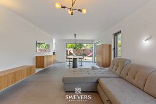 Interesse? Meer informatie op www.SWEVERS.be. - In de Jeugdstraat in Hasselt staat een volledig gerenoveerde halfopen woning die in 2023-2024 van fundering tot dak werd vernieuwd. Met een bewoonbare oppervlakte van 220 m² biedt het huis modern comfort, veel licht en een doordachte indeling. De ruime leefruimte loopt naadloos over in een open keuken met hoog plafond, vide en een volledig openklapbare Velux, wat zorgt voor een bijzonder open en lichte sfeer. Verder is er een bureau, een wasberging met handige waskoker, vloerverwarming op de eerste twee verdiepingen en voorzieningen voor airco en laadpalen. <br /><br />De drie slaapkamers zijn ruim en de badkamer is luxueus uitgerust met hoekbad, douche en dubbele lavabo, aangevuld met een aparte dressing. De zolder van meer dan 41 m² biedt uitbreidingsmogelijkheden voor extra kamers of een hobbyruimte. Buiten beschikt het perceel van 4a 31ca over twee private parkeerplaatsen op het perceel en een zonnige zuidgerichte tuin. De ligging in de Banneuxwijk combineert rust met nabijheid van scholen, openbaar vervoer, winkels en de snelweg. Hoewel de woning bijna instapklaar is, laat de afwerking op enkele punten nog ruimte voor een persoonlijke toets.<br /><br />Plan snel een bezichtiging en laat je betoveren door de unieke sfeer van deze woning! Wij helpen je maar al te graag verder tijdens een persoonlijke rondleiding. tel. 011 255 155. Bron bewoonbare oppervlakte: EPC – verslag.