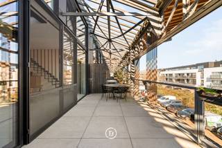 This exclusive duplex loft is part of Loods 23, a high-quality redevelopment project with a rich maritime history, located in a vibrant neighborhood with easy access to the city center and public transportation.<br /><br />The loft features a spacious living area of 191 m² and a sunny terrace of 26 m². A cellar storage is included, and there is the possibility to purchase a private parking space.<br /><br />Layout<br />Through the entrance hall with cloakroom and guest toilet, you enter a home that immediately impresses with its pronounced feeling of light, space, and openness.<br />The ground floor is characterized by high ceilings and includes a spacious living and dining area with an open kitchen and kitchen island. The kitchen is fully equipped with high-quality Miele appliances and has a cozy breakfast nook as an extension of the island. Adjacent is a practical storage room, currently used as a laundry and storage space.<br />The generous sun terrace of 26 m² is a natural extension of the living area.<br /><br />The first floor includes a versatile space (ideal as an office, hobby room), an open bedroom that can be closed off if desired, a full master bedroom, and a luxurious bathroom with a bathtub, walk-in shower, and sink, as well as a separate toilet.<br /><br />The loft is finished with high-quality and durable materials and is equipped with modern techniques including solar panels, air conditioning, mechanical ventilation, etc. The large windows enhance the open loft character and provide a contemporary, stylish look.<br />An exceptional living opportunity for those looking for something special.