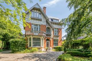 <p>Verscholen in het groen achter een sierlijk ijzeren hekwerk, vinden we deze uitzonderlijke villa die evenveel charme als verfijning uitstraalt. Deze 19<sup>de</sup> eeuwse art-nouveau villa, waar tijd geen haast lijkt te hebben, biedt vandaag een oase van rust.<br /><br />De verfijnde gevels, hoge plafonds, originele parketvloeren en schitterende glas-in-lood ramen ademen stijl, comfort en een tijdloze elegantie uit.<br />Met een royale bewoonbare oppervlakte van 470m², ingedeeld in meerdere woonkamers, een volledig uitgeruste keuken en 7 slaapkamers, biedt deze woning een overvloed aan mogelijkheden. De functionele indeling wordt bovendien versterkt door een apart bureau, 2 inpandige garages en een 4-tal kelderruimtes. Als kers op de taart, wordt deze woning omgeven door een schitterende aangelegde tuin, waar privacy en rust prioriteit zijn.<br /><br />Deze villa bevindt zich op een topligging tussen Aalst en Brussel, nabij de belangrijkste invalswegen en in de direkte nabijheid van het Aalsterse ziekenhuis A-Zorg.<br /><br />Grijp deze kans om deze unieke villa te transformeren naar uw droomhuis !<br />Voor meer informatie of het inplannen van een bezoek, aarzel niet om contact te nemen met Sabrina op 0470/03.31.39 of info@immobia.be<br /> </p>