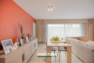 Ontdek dit ruim en lichtrijk appartement met een bewoonbare oppervlakte van ca. 102m², gelegen in een verzorgde residentie. Dankzij de grote raampartijen geniet u hier van een aangename natuurlijke lichtinval en een open woongevoel. Het appartement wordt momenteel verhuurd aan €1.053,27/maand, wat deze eigendom eveneens interessant maakt als investering. Bovendien beschikt het appartement over een gunstige EPC-score B en verkeert het in zeer verzorgde staat.Indeling2de verdieping: inkomhal, ruime woonkamer van ca. 36m² met toegang tot het terras, keuken, twee volwaardige slaapkamers, apart gastentoilet, badkamer uitgerust met zowel een bad, douche als toilet, en een berging.Kelderverdieping: garagebox, bij aan te kopen aan €25.000Karakteristieken- Bewoonbare oppervlakte van ca. 102m²- Ruime woonkamer van ca. 36m² met toegang tot het terras- Energiezuinig, EPC-score B- Momenteel verhuurd aan €1.053,27/maand- Bestuursmaatregelen in het maatregelenregister: neeBent u op zoek naar een ruim appartement met veel lichtinval, een praktische indeling en een interessante huuropbrengst? Dan is deze eigendom zeker een bezoek waard. Contacteer ons vandaag nog voor meer informatie of een bezoek ter plaatse via 02 460 80 46 of info@structura.be