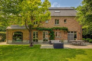 Achter een elegante houten poort, verscholen in het groen van een residentiële straat, schuilt deze charmante villa in landelijke stijl. Een...