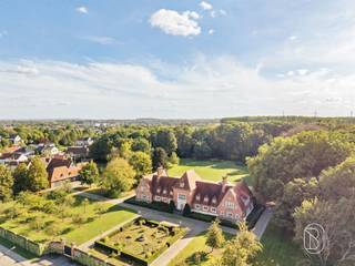 Te koop: exclusief landhuis op ca. 6 ha in Deerlijk. Prachtig groot degelijk landhuis, met een enorme potentieel! In een uitzonderlijk groen kader in Deerlijk bevindt zich dit statige landhuis, omringd door uitgestrekte botanische tuinen, bos en mature beplanting. Met een bewoonbare oppervlakte van ca. 752 m² en een domein van ca. 6 hectare biedt deze eigendom een zeldzame combinatie van grandeur, privacy en ruimte.Wat maakt deze eigendom uniek?Het landhuis wordt gekenmerkt door zijn klassieke architectuur en indrukwekkende volumes. Binnen beschikt de woning over maar liefst 7 slaapkamers en 5 badkamers, waardoor er volop ruimte is voor een groot gezin, gasten of andere invullingen. De ruime keuken is bereikbaar via de dienstingang en staat in verbinding met verschillende formele ontvangst- en leefruimtes. Grote raampartijen zorgen hier voor een prachtig contact met het omliggende groen en bieden uitzicht op het terras en de tuinen.Een absolute blikvanger is het domein van ca. 6 hectare. De zorgvuldig aangelegde botanische tuinen, volwassen bomen en bosrijke omgeving creëren een bijzonder gevoel van rust en absolute privacy.Voor wie is dit ideaal?Ideaal voor wie op zoek is naar een exclusief landgoed met uitzonderlijke privacy, royale woonvolumes en een indrukwekkend groen domein in Deerlijk.Te koop via Immo Beguin, jouw vastgoedexpert sinds 2009, met kantoren in Ronse, Waregem, Kortrijk, Deinze, Doornik, Lessines, Moeskroen en Nieuwpoort.