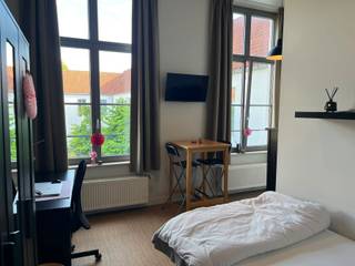 <p><span>Ruime en volledig gemeubelde studentenkamer in het hart van Brugge</span></p><p><span>Bent u op zoek naar een zorgeloze investering of een comfortabele verblijfplaats voor uw studerende zoon of dochter? Dan is deze instapklare studentenkamer in Residentie Campus Amicorum absoluut het ontdekken waard.</span></p><p><span>Gelegen in de Werkhuisstraat, op een steenworp van het historische centrum van Brugge, geniet deze studentenkamer van een uitstekende ligging nabij hogescholen, winkels, horecazaken en het station. De residentie werd in 2014 grondig gerenoveerd en combineert de charme van een karaktervol gebouw met het comfort van hedendaags wonen.</span></p><p><span>De kamer beschikt over hoge plafonds en grote raampartijen, wat zorgt voor een aangenaam ruimtelijk gevoel en veel natuurlijke lichtinval. Ze wordt volledig gemeubileerd verkocht en is voorzien van een comfortabel slaap- en leefgedeelte, een praktische kitchenette met kookplaat, dampkap, koelkast en spoelbak, en een private badkamer met douche, lavabo en toilet.</span></p><p><span>Bewoners kunnen bovendien gebruikmaken van diverse gemeenschappelijke voorzieningen, waaronder een prachtig aangelegde binnentuin waar het heerlijk vertoeven is, een ontspanningsruimte met televisie en een overdekte fietsenstalling.</span></p><p><span>Dankzij de verzorgde residentie, de eigen keuken en badkamer, de volledige meubilering en de centrale ligging vormt deze studentenkamer een interessante opportuniteit voor zowel ouders als investeerders. De grote vraag naar kwalitatieve studentenkamers in Brugge zorgt bovendien voor een aantrekkelijk verhuurpotentieel.</span></p><p><span>Een kwalitatieve studentenkamer op een toplocatie in Brugge, waar comfort, rust en investeringspotentieel perfect samenkomen.</span></p><p><span>Neem gerust contact met ons op voor meer informatie of een bezoek ter plaatse.</span></p>