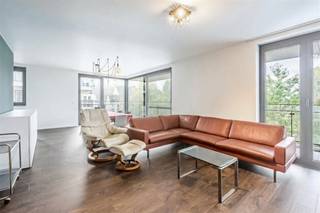 In de groene en rustige omgeving van Kloosterpark De Capucien bevindt zich dit prachtige hoekappartement met drie slaapkamers en een ruim, zuid- en westgericht terras. Het appartement maakt deel uit van Residentie Capuccio en biedt een schitterend uitzicht op het omliggende groen. Bij de ontwikkeling van het project werd veel aandacht besteed aan kwalitatieve materialen en een verfijnde afwerking, zowel in de gemeenschappelijke delen als in het appartement zelf.De indeling is als volgt: een inkomhal met ingemaakte vestiairekasten, een lichtrijke woonkamer, een semiopen en volledig uitgeruste keuken, een praktische berging, een apart toilet, drie slaapkamers en een badkamer.Een absolute troef is het ruime terras van maar liefst 49 m², dat zich rondom het hoekappartement uitstrekt. Daarnaast beschikt het appartement over een ruime terrasberging.Optioneel kan op niveau -1 een ruime, afgesloten garagebox met aansluitende berging worden aangekocht voor € 40.000.Het appartement is uitstekend geïsoleerd en geventileerd, wat resulteert in een gunstig EPC-label A. Bovendien voldoet de elektrische installatie aan de AREI-voorschriften.De belangrijkste troeven op een rij:Energiezuinig wonen dankzij EPC-label A.Op wandelafstand van het centrum van Aalst.Vlotte bereikbaarheid dankzij de nabijheid van de E40.Gelegen in een historische, groene omgeving.Tal van wandel- en fietsmogelijkheden in de buurt.Ruim terras van 49 m² met zuid- en westoriëntatie.Optionele garagebox met aansluitende berging.
