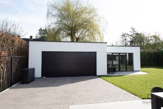 <p><span>EXCLUSIEF: Comfortabel wonen IN STIJL, denkt u aan een grote penthouse, maar wil u wonen in een rustige groene omgeving, bekijk deze exclusieve GELIJKVLOERSE villa!</span></p><p><span>Knappe energiezuinige moderne gelijkvloerse woonst + BIJGEBOUW in een aangename omgeving te Halle-Zoersel. </span></p><p><span>Luxueus wonen op de begane grond op ca 223m² met extra bijgebouw van 75m² als polyvalente ruimte, woon/werk situatie, zorgwoning,...</span></p><p><span>Dit eigendom is gelegen op een mooi stukje grond, opgeleverd in 2024, dus als nieuw, waarvan volledig het gelijkvloers is ingedeeld met inkomhal, toegang via smeedijzeren tussendeur naar de lichte leefruimte met uitzicht op de tuin en een open luxueuze ingerichte keuken met alle nodige inbouw toestellen, eveneens een dubbele vaatwasser, inductievuur, heteluchtoven, bordenverwarmer, 20m werkblad enz. Verder een ruime berging en wasplaats met technieken en aansluiting wasmachine/droogkast.</span></p><p><span>Groot schuifraam die toegang geeft tot het terras, aangelegde tuin met haag, grasrobot, volledig omheind en afgesloten met een automatische poort. </span></p><p><span>Alles is mooi afgewerkt van hoogstaande kwaliteit, opvallend zijn de plafondhoge glazen tussendeuren, ingemaakte kasten, mooie raamdecoratie, inbouwspots,... </span></p><p><span>Masterbedroom met dressing, automatische screens en ensuite badkamer met grote inloopdouche, lavabo, toilet,... deze slaapkamer heeft een schuifraam naar een open buitenruimte met privacy.</span></p><p><span>Verder op de riante nachthal is er een tweede en derde slaapkamer, waarvan 1 kamer vorzien is van een ingebouwd bureelmeubel, Er is een tweede badkamer met lavabo, douche en toilet. De slaapkamers en leefruimte zijn voorzien van airco via Daikin warmtepompsysteem (warm-koud).</span></p><p><span>Luxueuze afwerking met duurzame materialen, 16 zonnepanelen, HR TOP ketel op gas - vloerverwarming (hybride voorzieningen aanwezig), grote tegelvloer, HR+ beglazing in aluminium, stofzuigersysteem, alarmsysteem en CO² melder, gevelbepleistering Consteca, regenwaterput, E-peil 7!</span></p><p><span>Bijgebouw met overdekt terras, ideaal voor de laatste avondzon, 1 grote sectionaal poort met toegang tot een ruimte voor 2 wagens en een bijkomende polyvalente ruimte met groot raam naar de tuin, er zijn voorzieningen voor het inrichten tot kantoor/praktijkruimte, extra woonst,... momenteel in gebruik als fitness ruimte, er is drijfkracht in het bijgebouw.</span></p><p><span>Er is een vergunning voor het plaatsen van een zwembad.</span></p><p><span>Rustig gelegen met een goede verbinding naar uitvalswegen, in de omgeving van mooie fiets- en wandelroutes en nabij het dorp van Halle.</span></p><p><span>Instapklaar, prima onderhouden, contacteer ons voor bijkomende info en plan een bezoek!</span></p><p><span> </span></p><p><span> </span></p>