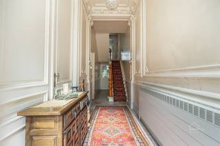 <p><strong>Authentiek herenhuis met 5 slaapkamers en tuin. </strong></p><p>Statig herenhuis dat de charme van weleer op een unieke manier bewaard heeft. Achter de gevel schuilt een woning met hoge plafonds, rijke sierlijsten, prachtige deuren met glas in lood en een indrukwekkende schouwpartij. Ideaal voor wie op zoek is naar karakter en ruimte.</p><p><strong>Indeling</strong></p><p>U betreedt de woning via een sfeervolle inkomhal met authentieke mozaïekvloer, marmeren lambrisering en fijn stucwerk. De hal geeft toegang tot de ruime, lichtrijke woonkamer met visgraatparket, hoge plafonds met moulures en een monumentale schouw in natuursteen. Aansluitend bevindt zich de eetkamer, gescheiden door prachtige deuren met glas in lood. Verder de keuken met aangrenzende eethoek, een douchekamer, apart toilet en berging. Achteraan geniet u van de tuin.</p><p>Op de eerste en tweede verdieping vinden we de 5 volwaardige slaapkamers alsook een extra toilet.</p><p><strong>Troeven</strong></p><ul><li>Authentieke elementen: mozaïekvloer, marmeren lambrisering, glas-in-lood, sierschouwen, houten trap met gesculpteerde trappaal, parket en plafondmoulures</li><li>Genereuze plafondhoogtes en veel natuurlijk licht</li><li>5 slaapkamers</li><li>Zonnige tuin</li><li>Gunstige locatie</li></ul>