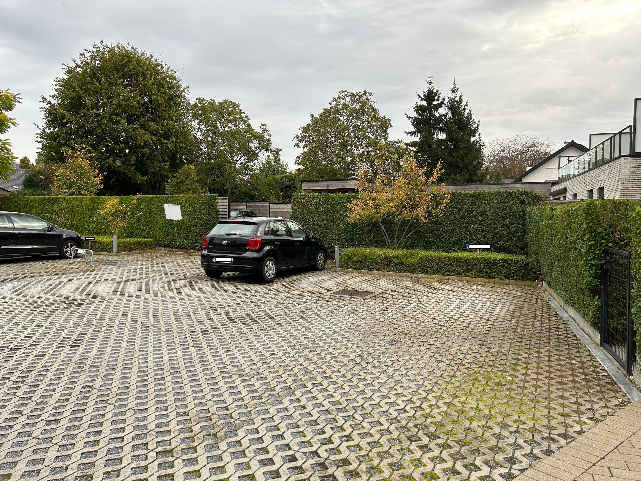 Deze privé parkeerplaats bevindt zich achter een appartementsgebouw en is vrij toegankelijk,.