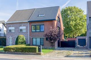 Sommige woningen voelen meteen juist. Dit is er zo eentje. Een halfopen bebouwing die van kop tot teen werd gerenoveerd, waar hedendaags wooncomfort en een warme, huiselijke sfeer elkaar moeiteloos vinden. Een plek waar alles klopt, van de technische uitrusting tot de laatste details, en waar het dagelijkse leven zich afspeelt in een decor dat uitnodigt om thuis te komen.<br /><br />Ook technisch staat deze woning bijzonder sterk. Met een <strong>EPC-label A, conforme elektrische keuring, lucht-luchtwarmtepompen en zonnepanelen met een vermogen van 7.245 Wp</strong> geniet je hier van een energiezuinige woning die helemaal klaar is voor de toekomst.<br /><br />Binnen verwelkomt de inkomhal je met een gastentoilet. Van daaruit vloeit de leefruimte over in de open keuken, aangevuld met een praktische berging. Achteraan vormt de eetkamer in de veranda een heerlijke plek om samen te komen. <strong>Grote raampartijen brengen het buitenleven naar binnen</strong> en laten de ruimte naadloos overlopen in het prachtig aangelegde terras. Een uitnodigend verlengstuk van de woning, waar lange zomeravonden en gezellige familiemomenten als vanzelf ontstaan.<br /><br />Ook buiten valt er heel wat te ontdekken. De garage van zo'n 30 m² beschikt over een bureaugedeelte met zicht op de verzorgde tuin. Deze biedt alle ruimte om te ontspannen, te spelen en te genieten. Het tuinhuis zorgt voor extra bergruimte en vormt tegelijk een bijzonder troef: langs hier krijg je <strong>rechtstreeks toegang tot het groene Puitvoetbos</strong>. Een heerlijke uitvalsbasis voor een wandeling, een fietstocht of gewoon even ontsnappen aan de drukte van alledag.<br /><br />Op de eerste verdieping bevinden zich drie kamers, waarvan één momenteel ingericht is als dressing en wasplaats, naast de badkamer. De tweede verdieping voegt daar nog twee volwaardige slaapkamers aan toe, ideaal voor een groter gezin, een thuiswerkplek of een hobbyruimte. Bovendien beschikt deze verdieping over een extra berging die zich uitstekend leent om om te vormen tot een tweede badkamer.<br /><br /><strong>Een instapklare gezinswoning met ruimte om te leven, energie om vooruit te kijken en groen om de hoek.</strong> Een thuis waar je niet eerst hoeft te renoveren of te plannen, maar meteen kunt beginnen genieten.<br /><br />Hebt u interesse? Of hebt u bijkomende vragen? Neem dan contact op via laurens@claves.be of op het nummer 0476 21 35 46.<br />