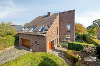 <strong>Immo Van Middelem biedt deze ruime villa aan in een rustige wijk te Lennik op een perceel van +/- 14a15. Een plek waar rust en groen de hoofdrol spelen, zonder in te boeten aan bereikbaarheid.<br /></strong><br />De woning onderscheidt zich door haar originele architectuur, speelse niveauverschillen en doordachte indeling. De verschillende leefruimtes zorgen voor een bijzondere ruimtebeleving en geven de villa een geheel eigen karakter.<br /><br />Een absolute blikvanger is de prachtige tuin, ontworpen en aangelegd door tuinarchitect Paul Beyl. De sierlijke vormen, zorgvuldig gekozen beplanting en verschillende groene hoekjes vormen samen een harmonieus geheel waar rust en privacy centraal staan.<br /><br />De indeling is als volgt:<br />- GELIJKVLOERS: inkomhal met vestiaire, gastentoilet, toegang tot de garage, lichtrijke woonkamer en eethoek met toegang tot het terras en de tuin, open keuken met ontbijthoek en toegang tot het terras en wasplaats; <br />- dubbele GARAGE;<br />- 1ste NIVEAU: 2 ruime slaapkamers, 1 apart WC;<br />- 2de NIVEAU: 2 ruime slaapkamers waarvan 1 met toegang tot het zonneterras, badkamer met douche, bad en dubbele lavabo;<br />- KELDERVERDIEPING: de woning is deels onderkelderd en onderverdeeld in een technische ruimte en 2 kelders.<br /><br />Solide betonnen structuur.<br />EPC: 162Kwh/m².jaar - Label B (UC:3955670).<br />Elektrische installatie CONFORM AREI tot 2042.<br />22 zonnepanelen met 7590Wp..<br />Vrij vanaf 01/07/2027.