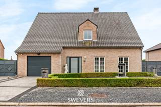 Voor meer info en foto’s, surf naar www.swevers.be – Deze ruime open bebouwing in Nieuwerkerken biedt met een bewoonbare oppervlakte van 239 m² alle comfort voor een groot gezin. De woning werd gebouwd in 1996 en ligt op een zuidgericht perceel van 8 are aan de Wouterveld 56. Via de inkomhal met gastentoilet bereikt u de lichtrijke leefruimte, waar zithoek, eetkamer en keuken mooi in elkaar overlopen. De keuken beschikt over voldoende werk- en bergruimte voor dagelijks gebruik. Op het gelijkvloers bevindt zich bovendien een ruime slaapkamer en een badkamer met ligbad en enkele wastafel. De eerste verdieping telt vier volwaardige slaapkamers van respectievelijk 18 m², 16 m², 16 m² en 16 m². Daarnaast is er een tweede badkamer met inloopdouche, toilet en een dubbele wastafel. De ruime open zolderverdieping op de tweede verdieping biedt tal van mogelijkheden als extra slaapkamer, hobbyruimte of extra opslagplaats. Ook praktisch scoort deze woning sterk dankzij de garage van 23 m² . Doorheen de jaren werd de woning zorgvuldig onderhouden en op verschillende vlakken vernieuwd. Daarnaast werden in 2018 zonnepanelen geplaatst, wat bijdraagt aan een lagere energiefactuur. Recente investeringen omvatten de plaatsing van een warmtepomp en een gaskachel in 2023, wat zorgt voor extra comfort en een efficiënte verwarming van de woning. Buiten geniet u van een zonnige, zuidgerichte tuin waar kinderen kunnen spelen en waar u optimaal kan genieten van lange zomeravonden. De ligging is bovendien bijzonder gunstig, met scholen en kinderopvang op wandelafstand, een bushalte op slechts 150 meter, winkels en ontspanningsmogelijkheden in de buurt en een vlotte verbinding naar het station en de autosnelweg. Bent u op zoek naar een ruime gezinswoning met vijf slaapkamers, twee badkamers, zonnepanelen en een zonnig perceel in Nieuwerkerken? Dan is deze woning zeker een bezoek waard. Voor meer informatie, bel 012 699 900. Bron bewoonbare oppervlakte: EPC – verslag
