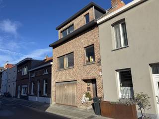 Deze degelijk charmante woning met garage is gelegen in een rustige straat nabij Telenet.Bij binnenkomst betreden we de woning via de hal en de ruime garage(48m²) met CV berging.Op de eerste verdieping vinden we de ruime living met haard en aansluitend keuken met terras(12m²) alsook gastentoilet.Het tweede verdiep beschikt over 2 ruime slaapkamers, badkamer en traphal.In de directe omgeving vindt u winkels, scholen en ontspanningsmogelijkheden. Het station Mechelen-Nekkerspoel bevindt zich op wandelafstand en ook het centrum van Mechelen is gemakkelijk bereikbaar te voet of met de fiets. Met de wagen geniet u bovendien van een snelle verbinding naar de E19 richting Antwerpen en Brussel via de nabijgelegen R6.