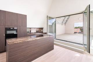 <div>
<div>
<section>
<div>
<div>
<div>
<div>
<div>
<div>
<p>Ontdek dit exclusieve duplex penthouse van <strong>125 m²</strong>, gelegen op de vernieuwde Slachthuissite in Antwerpen. Deze recente nieuwbouwwoning combineert hoogwaardige afwerking, een overvloed aan natuurlijk licht en maar liefst <strong>66 m² aan terrassen</strong>, verdeeld over twee buitenruimtes.</p>
<p>De duplex beschikt over een ruime leefruimte met grote raampartijen, een luxueuze open keuken met kookeiland, <strong>3 volwaardige slaapkamers</strong> en <strong>2 stijlvolle badkamers</strong>, waarvan één met een inloopdouche en één met een ligbad. Dankzij de hoge plafonds en de grote dakramen geniet u de hele dag van een uitzonderlijk ruimtelijk gevoel.</p>
<p>Het absolute pronkstuk is het indrukwekkende <strong>dakterras van 51 m²</strong>, aangevuld met een tweede terras van <strong>15 m²</strong>, ideaal om in alle rust van de zon en het open uitzicht te genieten.</p>
<p>De verkoop omvat bovendien een <strong>privatieve kelderberging en twee ondergrondse autostaanplaatsen</strong>, inbegrepen in de vraagprijs.</p>
<p>Gelegen vlak bij Park Spoor Noord, het Eilandje, winkels, horeca en openbaar vervoer biedt dit penthouse een unieke combinatie van luxe, comfort en een uitstekende bereikbaarheid.</p>
</div>
</div>
</div>
</div>
</div>
</div>
</section>
</div>
</div>