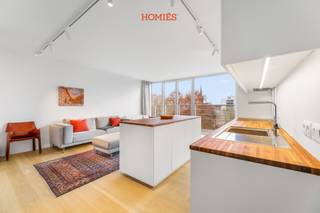 Dit modern éénslaapkamerappartement bevindt zich in de Fonteinstraat 75, midden in het centrum van Leuven, op wandelafstand van supermarkten, winkels, bushaltes en meteen naast het Bruulpark. Op de vijfde verdieping geniet u van een ruim, open uitzicht over de stad dat ’s avonds bijzonder sfeervol wordt door de vele lichtjes. Dankzij het gunstige EPC-label B in combinatie met 58 m² (ref. EPC) is dit een efficiënte en duurzame woonoplossing. U komt binnen via een inkomhal met apart toilet en bereikt vervolgens de lichte leefruimte met grote raampartijen. De open keuken beschikt over een kookeiland en veel opbergruimte, aangevuld met ingebouwde kasten in de leefruimte. Het appartement werd ongeveer vijf jaar geleden volledig gerenoveerd met kwaliteitsvolle materialen. Bovendien kunnen de meeste meubels worden overgenomen. Aansluitend aan de leefruimte bevindt zich de ruime slaapkamer met ensuite badkamer, wat zorgt voor een praktische en comfortabele indeling. Daarbovenop beschikt het appartement over een privatieve garagebox, een kelderberging en een gemeenschappelijke, inpandige fietsenstalling. Dankzij de centrale ligging en het zorgvuldige comfortaanbod is dit een ideale keuze als startersappartement, een slimme investering, voor studerende kinderen of een perfect appartement voor koppels, alleenstaanden, … kortom, een eigendom met veel mogelijkheden. Interesse? Aarzel dan niet om ons te contacteren via info@homies.be of via 016 22 82 22.