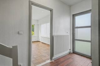 In een rustige doodlopende straat in Haasdonk bevindt zich deze open bebouwing op een mooi perceel met veel privacy. Dankzij de combinatie van ruimte, een gunstige EPC-score en een uitstekende ligging nabij het centrum en de E17 vormt deze woning een ideale thuisbasis voor gezinnen.<br /><br />Bij het binnenkomen word je verwelkomd in een inkomhal met vestiaire en gastentoilet. Van hieruit bereik je de gezellige leefruimte, met open haard. Hier zorgen de grote raampartijen voor veel natuurlijke lichtinval en een mooi zicht op de tuin. Aansluitend bevindt zich de keuken, die voldoende ruimte biedt en ook zicht op de tuin.<br /><br />Verder beschikt het gelijkvloers over een inpandige garage met extra bergruimte.<br /><br />Op de verdieping bevinden zich vier ruime slaapkamers en een badkamer uitgerust met ligbad, dubbele lavabo en toilet. Via een uitschuifbare trap bereik je de praktische zolderruimte.<br />Buiten geniet je van een ruime verzorgde tuin. De twee terrassen zorgen ervoor dat je op elk moment van de dag een aangename plek in de zon of schaduw vindt. Daarnaast is er nog een tuinhuis aanwezig.<br /><br />Extra troeven:<br />-	EPC C – geen renovatieplicht<br />-	Open bebouwing in kindvriendelijke woonwijk<br />-	4 ruime slaapkamers<br />-	Inpandige garage<br />-	Buitenmuren geïsoleerd<br />-	Aluminium ramen met hoogrendementsglas<br />-	Twee terrassen en ruim tuinhuis<br />-	Vlotte verbinding naar E17, Antwerpen en Gent<br /><br />Een woning met sterke basis, veel ruimte en een uitstekende ligging voor wie rustig wil wonen zonder in te boeten op bereikbaarheid.<br /><br />Interesse? Contacteer ons via 052 46 38 03 voor meer informatie of een bezoek.<br />
