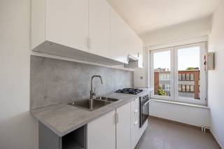 <p><span> </span></p><p><span>Op zoek naar een fris, energiezuinig appartement op een centrale ligging in Deurne?</span></p><p><span>Welkom in dit lichtrijke appartement met vernieuwde keuken, nette afwerking en twee volwaardige slaapkamers – mét toegang tot een gezellig terras. De locatie, tussen het prachtige Rivierenhof en Ertbrugge, winkels én openbaar vervoer, maakt het helemaal af!</span></p><p><span> </span></p><p><span>Fris, licht & praktisch ingedeeld</span></p><p><span>Via de inkomhal stap je het appartement binnen. Die vormt de centrale spil en geeft toegang tot alle ruimtes. Aan de straatzijde ligt de grote, lichtrijke leefruimte met nieuwe laminaatvloer en brede raampartijen over de hele gevelbreedte. Hier valt het daglicht overvloedig binnen – ideaal voor een gezellige zithoek met zicht op de buurt.</span></p><p><span>De aangrenzende keuken is vernieuwd en fris wit afgewerkt. Ze is voorzien van een gasvuur met dampkap, een oven, spoelbak en aansluiting voor wasmachine of vaatwasser. Het onderhoudsvriendelijke spatwand en het natuurlijke licht maken deze compleet.</span></p><p><span> </span></p><p><span>Twee slaapkamers & terrasje</span></p><p><span>Aan de rustige achterzijde van het gebouw liggen de twee slaapkamers: een masterbedroom van ca. 15 m² en een tweede kamer van ca. 9 m². Beide zijn voorzien van dezelfde nette vloer, witte muren en radiatoren. De tweede kamer heeft toegang tot een fijn terrasje van ca. 4 m² – een plek voor koffie in de zon met zicht op groen.</span></p><p><span>De badkamer is netjes en volledig: een douche, lavabo met meubel, spiegelkast én toilet zijn aanwezig.</span></p><p><span> </span></p><p><span>Centrale ligging met alles dichtbij</span></p><p><span>Het appartement bevindt zich op wandelafstand van het Rivierenhof – het groene hart van Deurne – waar je heerlijk kunt wandelen, sporten of iets gaan drinken aan het water. Ook het Wim Saerensplein met zijn markt, horeca en winkels ligt vlakbij. Mobiliteit? Check: tram- en bushaltes op wandelafstand, verschillende invalswegen én het Wijnegem Shopping Center op een boogscheut.</span></p><p><span> </span></p>