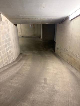 Goed gelegen en ruime garagebox te koop in het centrum van Heist. De garage bevindt zich op niveau -2, eenvoudig bereikbaar via een hellingsbaan, en heeft een lengte van 5,05 meter en een breedte van  3,65 meter, waardoor er nog gemakkelijk fietsen naast de auto kunnen geplaatst worden. De hoogte bedraagt 1,97 meter op het laagste punt en de inrijbreedte van de poort  is 2,50 meter.