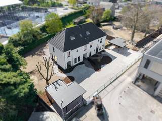 In tweede lijn, omgeven door rust en groen, bevindt zich deze uiterst kwalitatieve nieuwbouwwoning die ruimte, licht en verfijning moeiteloos combineert. De woning ademt een landelijke sereniteit, verfijnd vertaald naar hedendaags wooncomfort met een uitgesproken high-end afwerking. Elk detail werd met zorg gekozen — kosten noch moeite werden gespaard — en enkel duurzame, hoogwaardige materialen vonden hier hun plaats. Een woning die vandaag al klaar is voor morgen.<br /><br />Het betreft de linkse woning bij vooraanzicht (lot 3).<br /><br />De architectuur en indeling zijn doordacht tot in de finesse: royale leefruimtes, een optimale lichtinval dankzij grote glaspartijen en een volledige harmonie tussen binnen en buiten, met zicht en toegang tot de tuin rondom.<br /><br />Ook de buitenaanleg wordt volledig afgewerkt met oog voor esthetiek en functionaliteit. Oprijlaan, voortuin, inkompad, terras en parkeerstroken worden uitgevoerd in waterpasserende kleiklinkers met organische vormen. In de voortuin bevindt zich een carport met extra tuinberging. Zwarte omheining, betonplint en ericamatten zorgen voor maximale privacy, terwijl achteraan een haag van laurierkers een groene, natuurlijke afsluiting vormt.<br /><br />Indeling gelijkvloers:<br /><br />- Royale inkomhal met gastentoilet<br />- Zeer lichtrijke leefruimte met zit- en eethoek<br />- Open, volledig uitgeruste keuken met volkeramisch werkblad met afgeronde hoeken, dubbele spoelbak, inductiekookplaat, telescopische dampkap, koelkast, oven, microgolf en vaatwasmachine<br />- Praktische wasplaats/berging<br />- Afgesloten bureauruimte met stijlvolle stalen deuren<br /><br />Verdieping:<br /><br />- Ruime nachthal<br />- Apart toilet<br />- Drie volwaardige slaapkamers, waaronder een master bedroom met ensuite dressing<br />- Luxe badkamer met ligbad, dubbele lavabo en inloopdouche<br /><br />Via een vaste trap bereikt u de zolderverdieping, waar reeds Velux-ramen voorzien zijn en uitbreidingsmogelijkheden bestaan voor extra kamers.<br /><br />Extra troeven:<br /><br />- Lucht-water warmtepomp met vloerverwarming op gelijkvloers én verdieping<br />- Regenwaterput van 10.000 liter<br />- Zwarte PVC-ramen (RAL 9005) met kleinhouten en dubbele beglazing<br />- Ventilatiesysteem type D<br />- Conforme elektriciteit<br />- Volledige voorbereidingen voor internet, coax, zonneluifel, screens, thuisbatterij en koelcel<br />- Volkeramische vloeren, massief parket in de leefruimte en laminaat op de verdieping<br />- Venstertabletten in arduin<br />- Vaste eiken trappen<br /><br />Kortom: een uitzonderlijk luxueus woonproject dat klasse en tijdloze elegantie uitstraalt, versterkt door de prachtig gekaleide gevels.<br /><br />De afbeeldingen met meubelen zijn louter ter illustratie.
