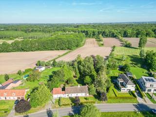 <p>Een oase van rust, omringd door open velden en groen. Deze karaktervolle 19de-eeuwse woning combineert authentieke charme met hedendaags comfort én tal van mogelijkheden voor wonen en werken.</p>
<p></p>
<p>Op een prachtig perceel van 1.831 m² geniet je van een mooie, ruime tuin met volwassen bomen en veel groen. Dankzij de grote ramen en de mooie verbinding tussen binnen en buiten geniet je ook vanuit de woning volop van het omliggende landschap.</p>
<p></p>
<p>Met een bewoonbare oppervlakte van 265 m² is ruimte hier absoluut geen probleem. De woning beschikt over 3 slaapkamers, met de mogelijkheid om dankzij de aanwezige bureau-/praktijkruimtes uit te breiden tot 5 slaapkamers. Ideaal voor wie een combinatie zoekt van privé wonen en een zelfstandige activiteit, praktijk of kantoor aan huis.</p>
<p></p>
<p>De rustieke elementen in de woning zorgen voor een unieke knipoog naar het verleden, terwijl het nodige hedendaagse comfort aanwezig is. Verder beschikt de woning over een carport en is er voldoende parkeergelegenheid voor de deur.</p>
<p></p>
<p>De woning beschikt momenteel over een minder gunstige EPC-score, wat uiteraard mogelijkheden biedt voor wie de woning verder energetisch wil optimaliseren en naar eigen smaak wil vernieuwen.</p>
<p></p>
<p>De indeling is als volgt:</p>
<p>Het gelijkvloers voorziet in een inkomhall met toegang naar de leefruimte, keuken en bureau. Verder vind je de badkamer (met ligbad en douche) en apart toilet. De doorgang naar het praktijdgedeelte geeft uit op de praktijk met twee bureau’s (1 per niveau).</p>
<p></p>
<p>De verdieping bestaat uit de nachthall, drie slaapkamers en een tweede toilet.</p>
<p></p>
<p>Buiten vinden we de tuinberging, een ruim tuinhuis en een carport.</p>
<p></p>
<p>Een unieke woning voor wie op zoek is naar karakter, ruimte, groen en vooral… een uitzonderlijk rustige ligging!</p>
<p></p>