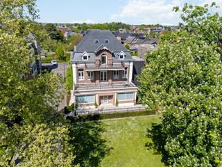 Cette maison de commerce pleine de caractère a été entièrement rénovée selon les normes contemporaines et finie avec des matériaux de haute qualité. Elle est située au bout d'une impasse, à distance de marche du marché de Geel. Toutes les commodités se trouvent à proximité, des magasins, des écoles, des transports en commun, des terrains de sport et des restaurants. Cette maison de maître au charme indéniable a été construite dans les années 1900, rénovée en 2013, 2017 et 2018. La propriété a une belle surface habitable d'environ 704 m².<br /><br />Rez-de-chaussée<br />Le rez-de-chaussée est organisé autour du hall d'entrée avec toilettes pour invités et vestiaire. Les deux espaces commerciaux ou de bureau se trouvent à l'avant de la maison et peuvent être aménagés ou modifiés selon vos souhaits. En outre, au rez-de-chaussée, on trouve une cuisine entièrement équipée avec une salle à manger spacieuse et un salon. Depuis la cuisine, on accède à une belle terrasse aménagée avec un étang.<br /><br />Étages<br />Le premier étage abrite un espace polyvalent actuellement aménagé en deuxième salon avec cuisine attenante. Vous pourrez également profiter de la terrasse avec vue sur le domaine du parc. La suite parentale, un dressing, une buanderie avec salle de bains attenante et des toilettes séparées. La grande salle de bains est équipée d'une baignoire, d'une grande douche à l'italienne, d'un lavabo, de toilettes et d'un bidet. Au deuxième étage, vous trouverez quatre chambres, deux salles de bains et des toilettes séparées. Il y a également une belle terrasse ensoleillée à cet étage. Enfin, le dernier niveau offre une grande chambre et un espace de rangement.<br /><br />Cave<br />La maison dispose d'une grande cave. La cave est aménagée comme suit : espace de détente, espace de rangement, buanderie avec chute à linge et local à vélos. La cave donne également accès à l'entrée latérale et au garage double intégré avec atelier.<br /><br />Particularités :<br />- Possibilités d'espace commercial ou de bureau<br />- Maison économe en énergie, certificat PEB A<br />- Chauffage au sol<br />- Système d'aspiration central<br />- Garage double intégré avec atelier<br />- Placards intégrés dans toute la maison<br />- Matériaux de haute qualité<br />- Caractère unique<br />- Station de recharge pour voiture électrique<br />Idéal pour combiner habitation et activité professionnelle !
